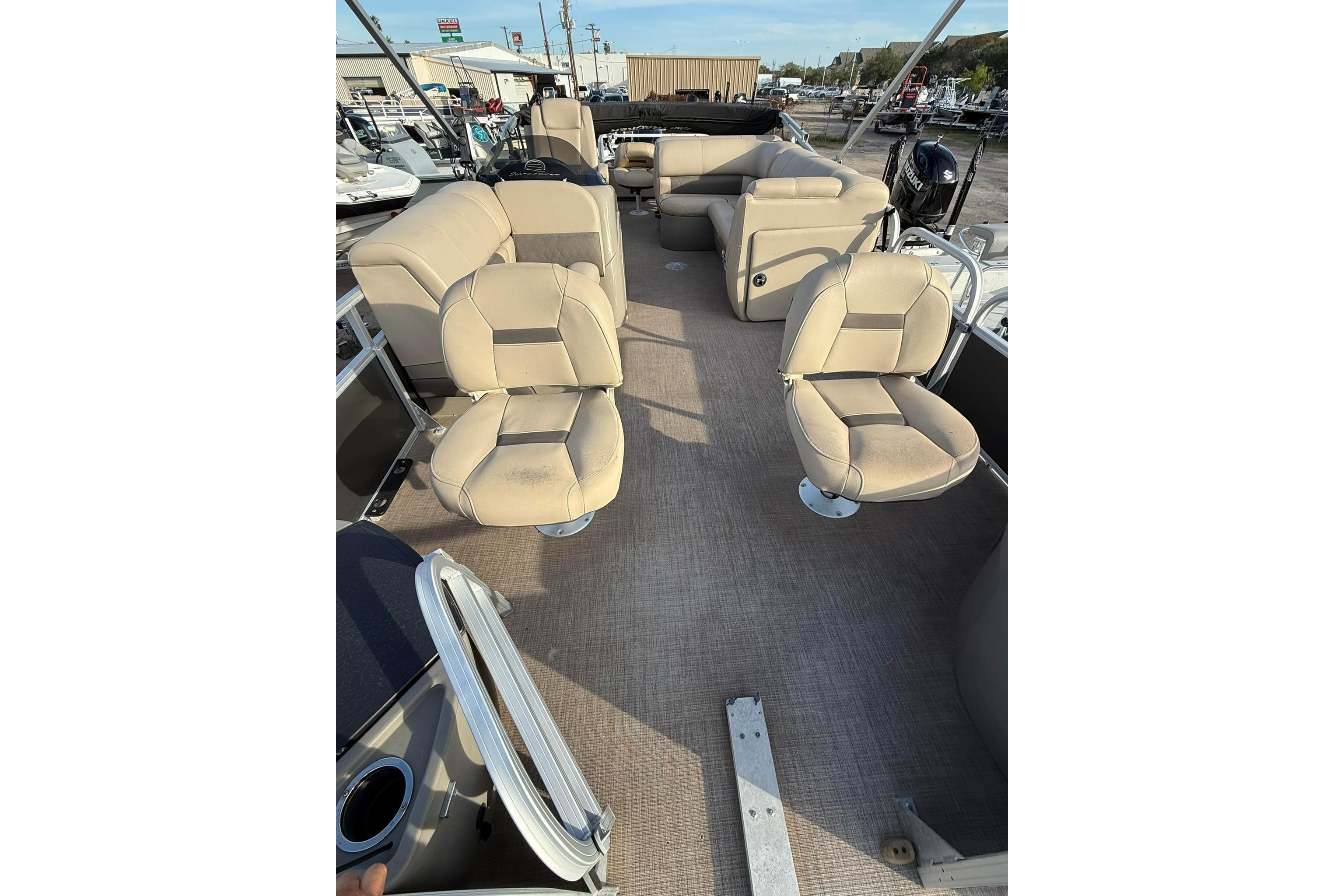 2023 Sun Tracker Fishin' Barge 22 DLX interior with beige seating and spacious layout.