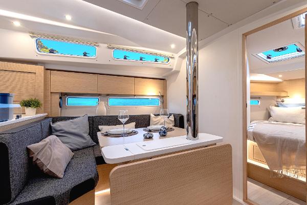 Interior of 2025 Hanse 360 yacht, featuring modern dining area and cozy bedroom.