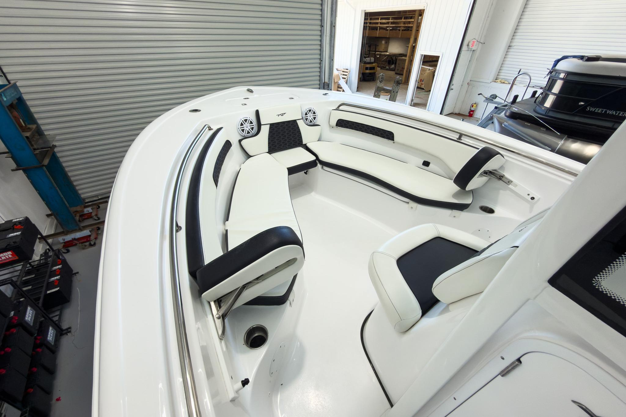 The image shows the deck of a Tidewater 220 LXF boat with white upholstery.
