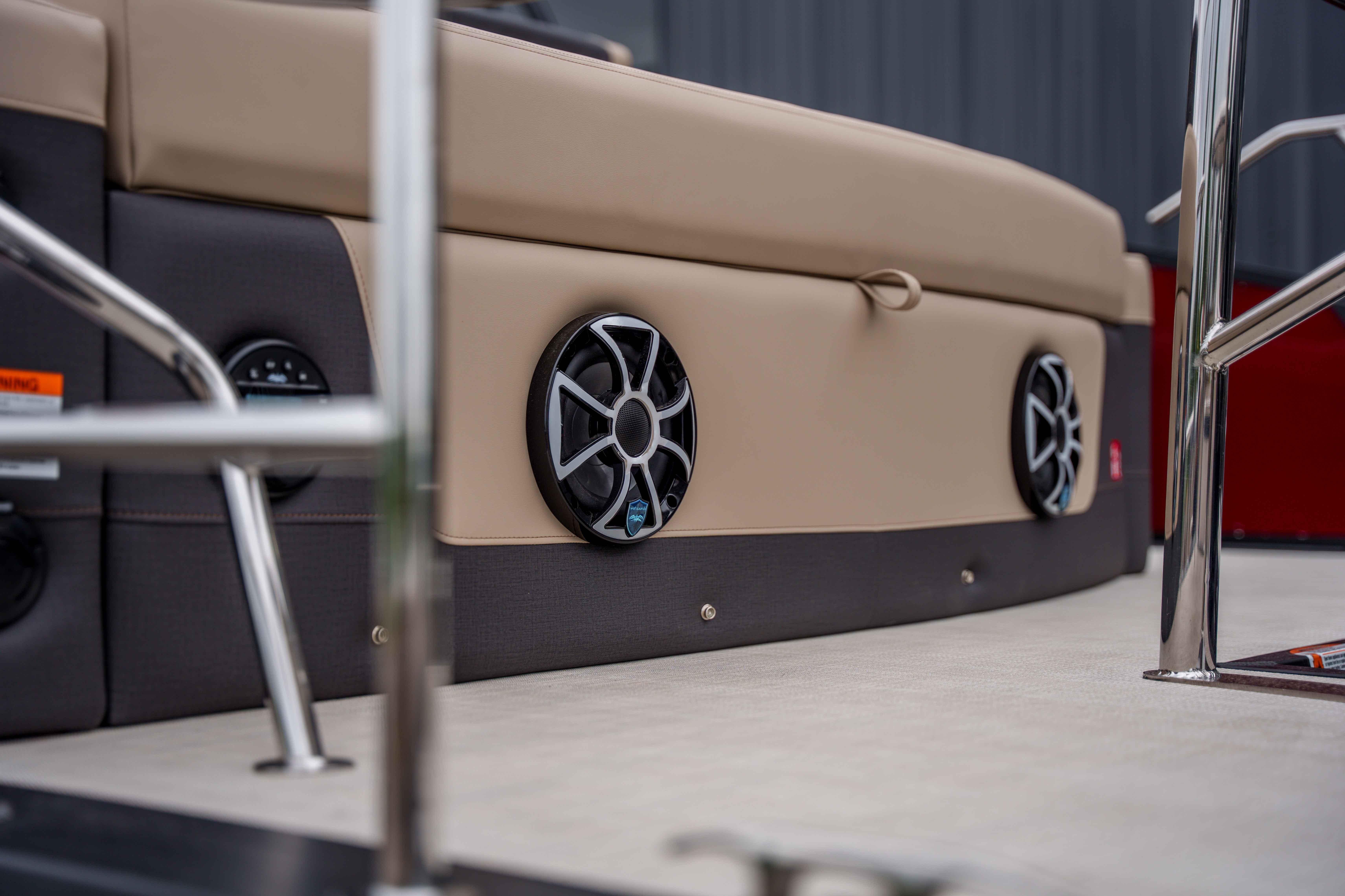 2026 Harris Sunliner 230 boat interior with built-in speakers and beige seating.