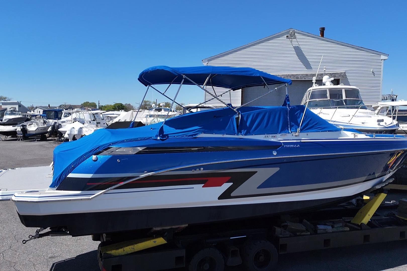 2018 Formula 330 Crossover Bowrider I/O with blue cover, parked at a marina.
