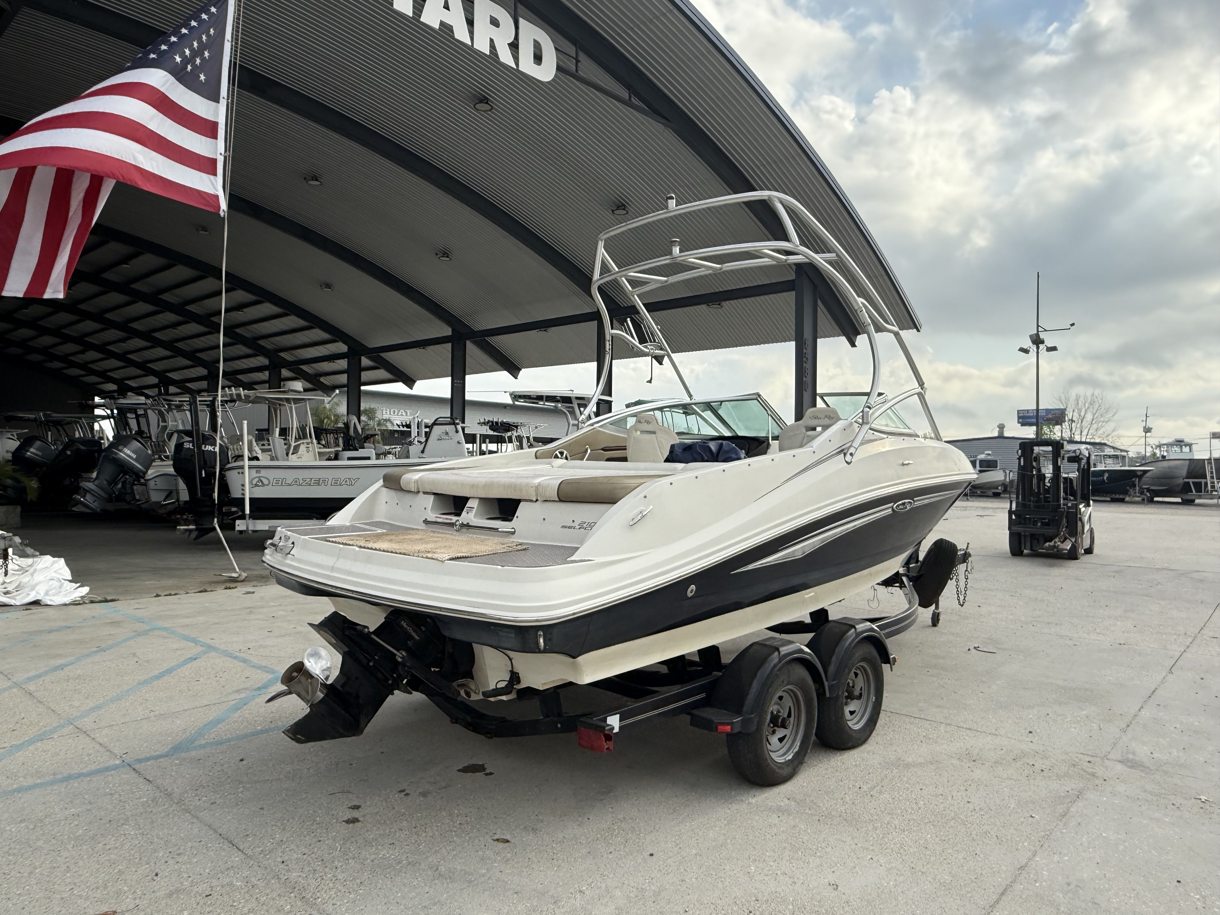 2007 Sea Ray 210 boat on trailer under American flag.