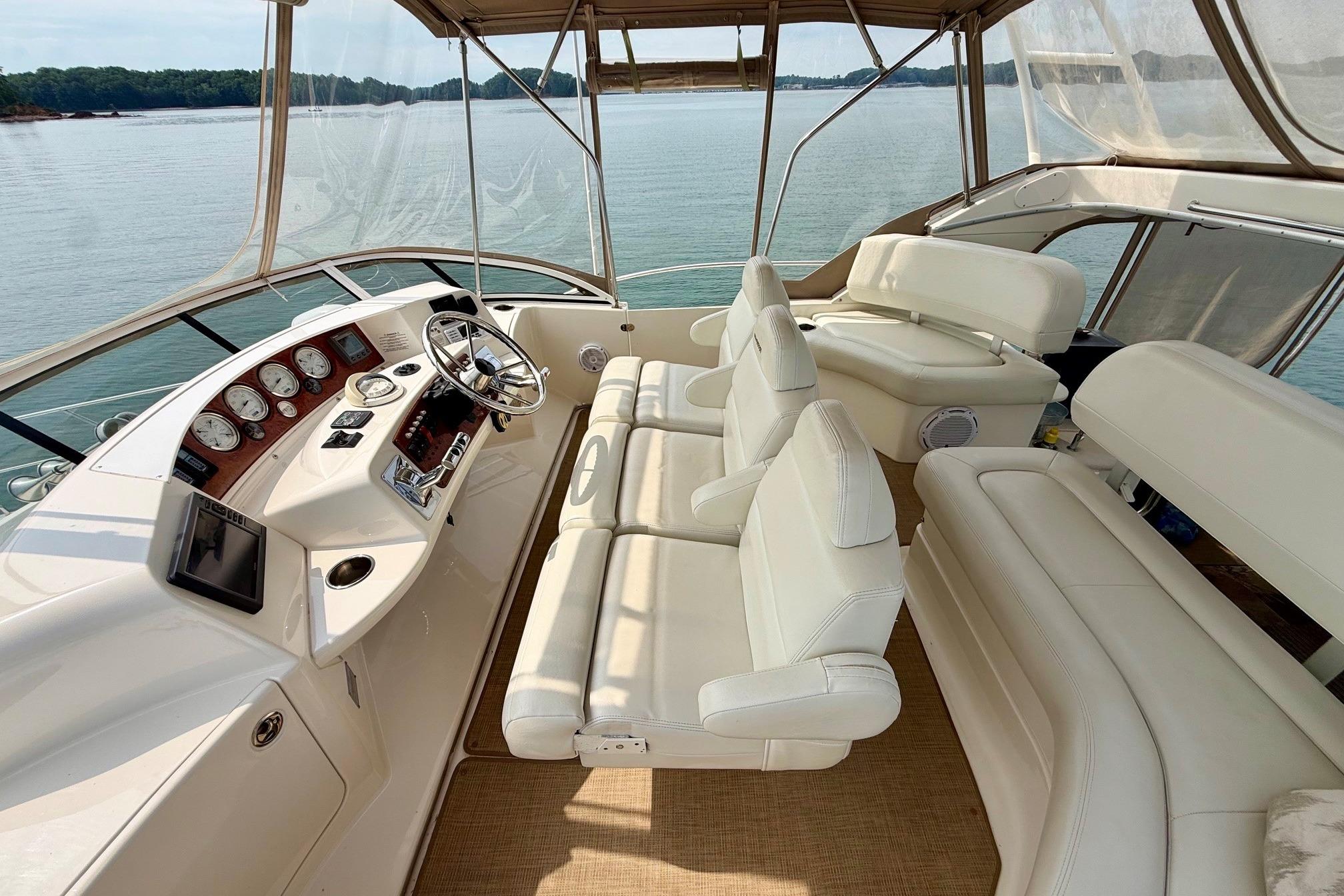 2004 Silverton 39 Motor Yacht interior with white seating and control panel, overlooking serene waters.