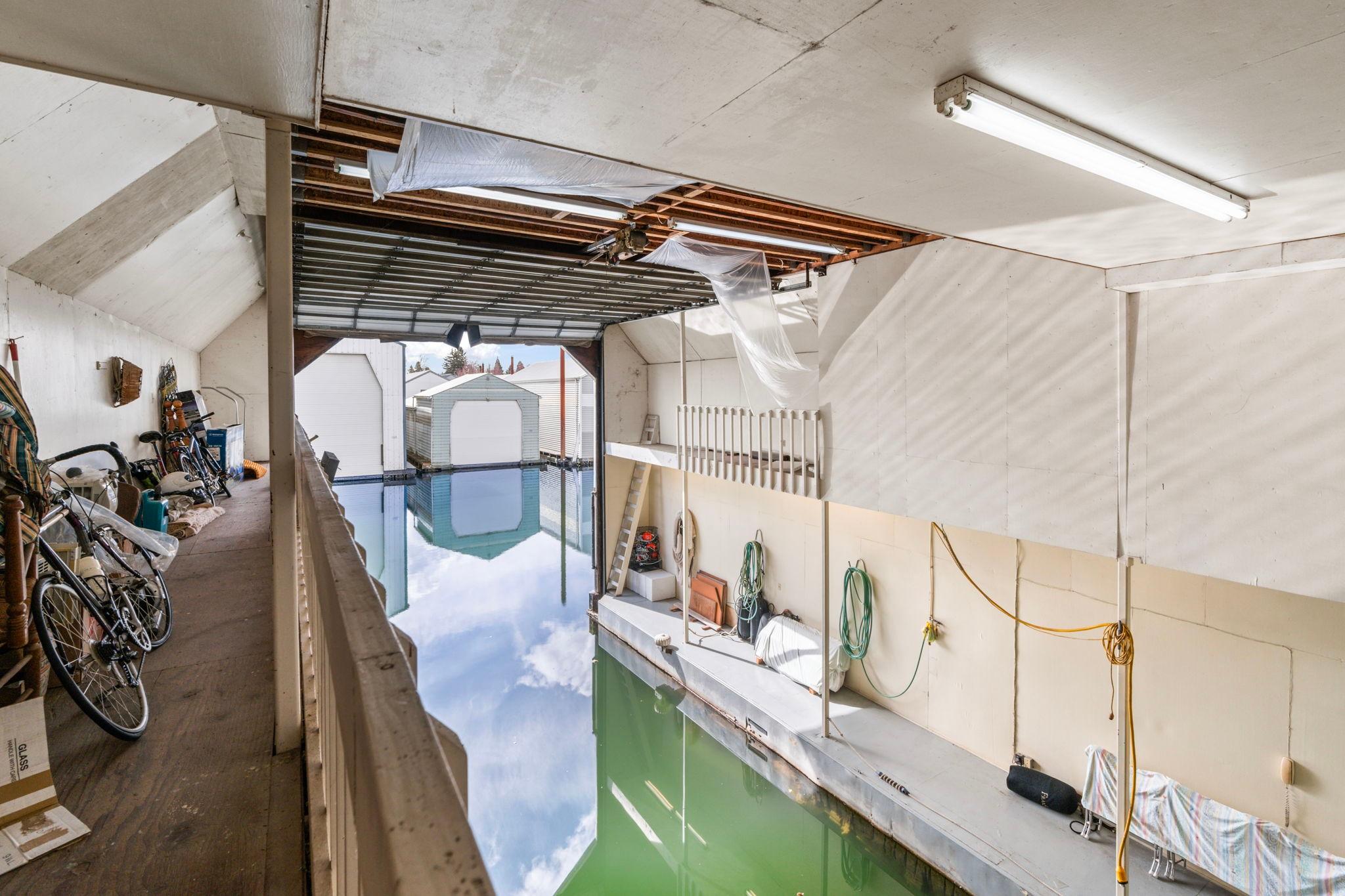 Interior of a 1976 custom boathouse with bicycles and water reflection.