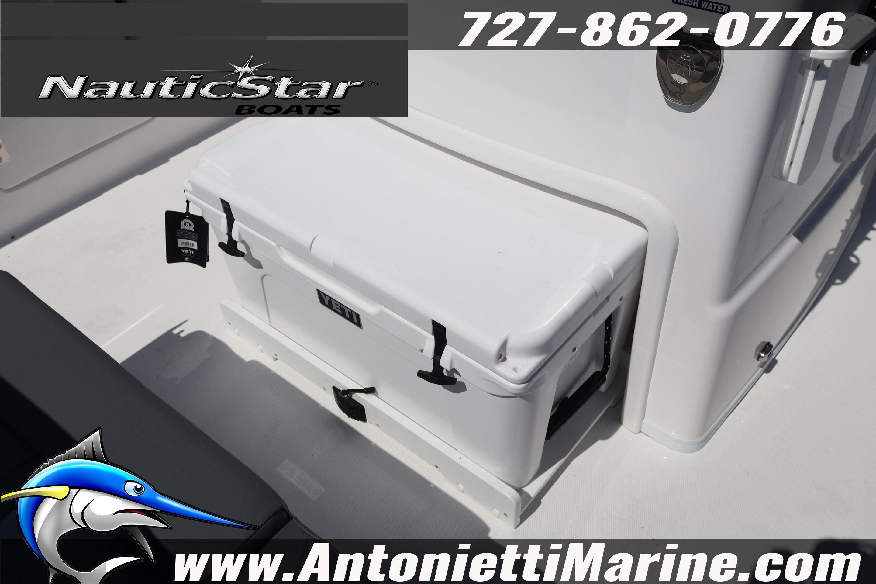 NauticStar 292 Legacy boat deck featuring a YETI cooler, contact info, and website details.