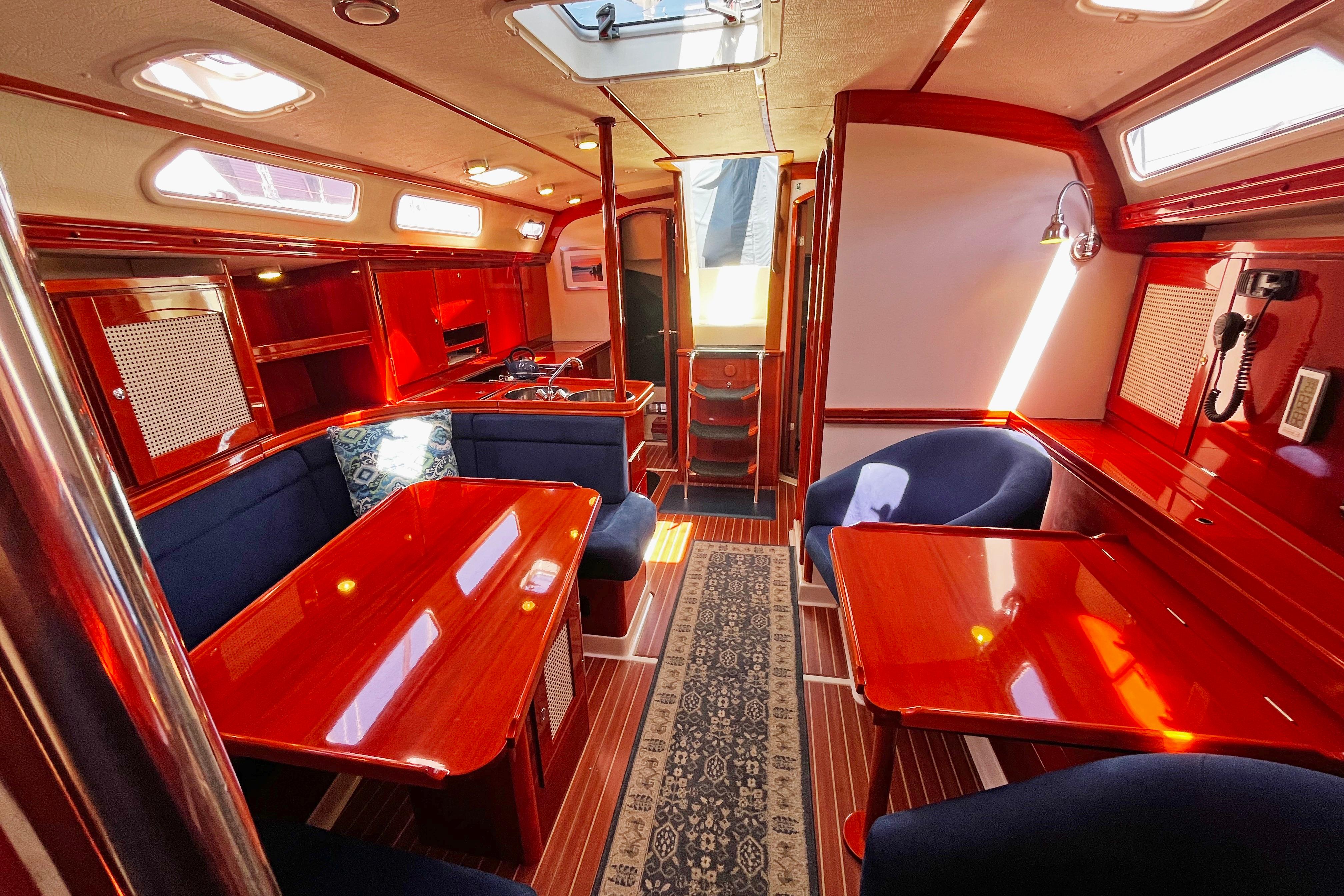 Luxurious 2004 Hanse 411 yacht interior with polished wood, navy seating, and elegant decor.