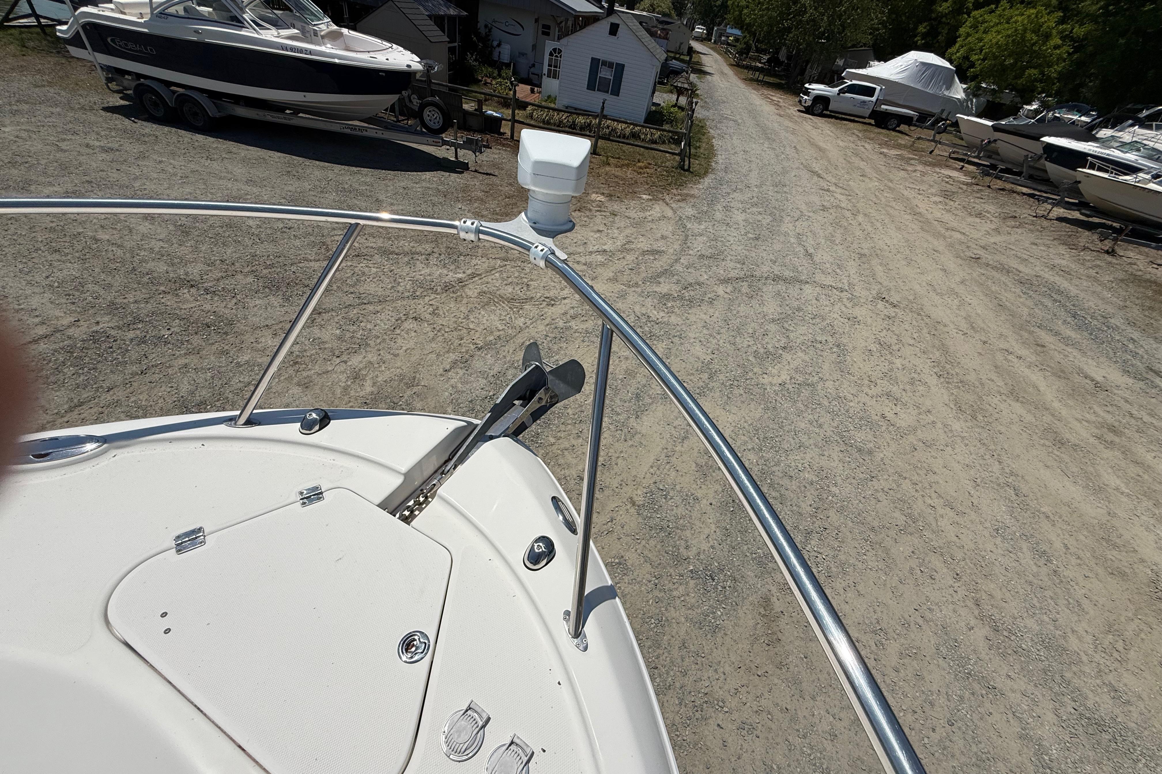 Bow view of 2007 Robalo R305 Walkaround boat in a marina setting.