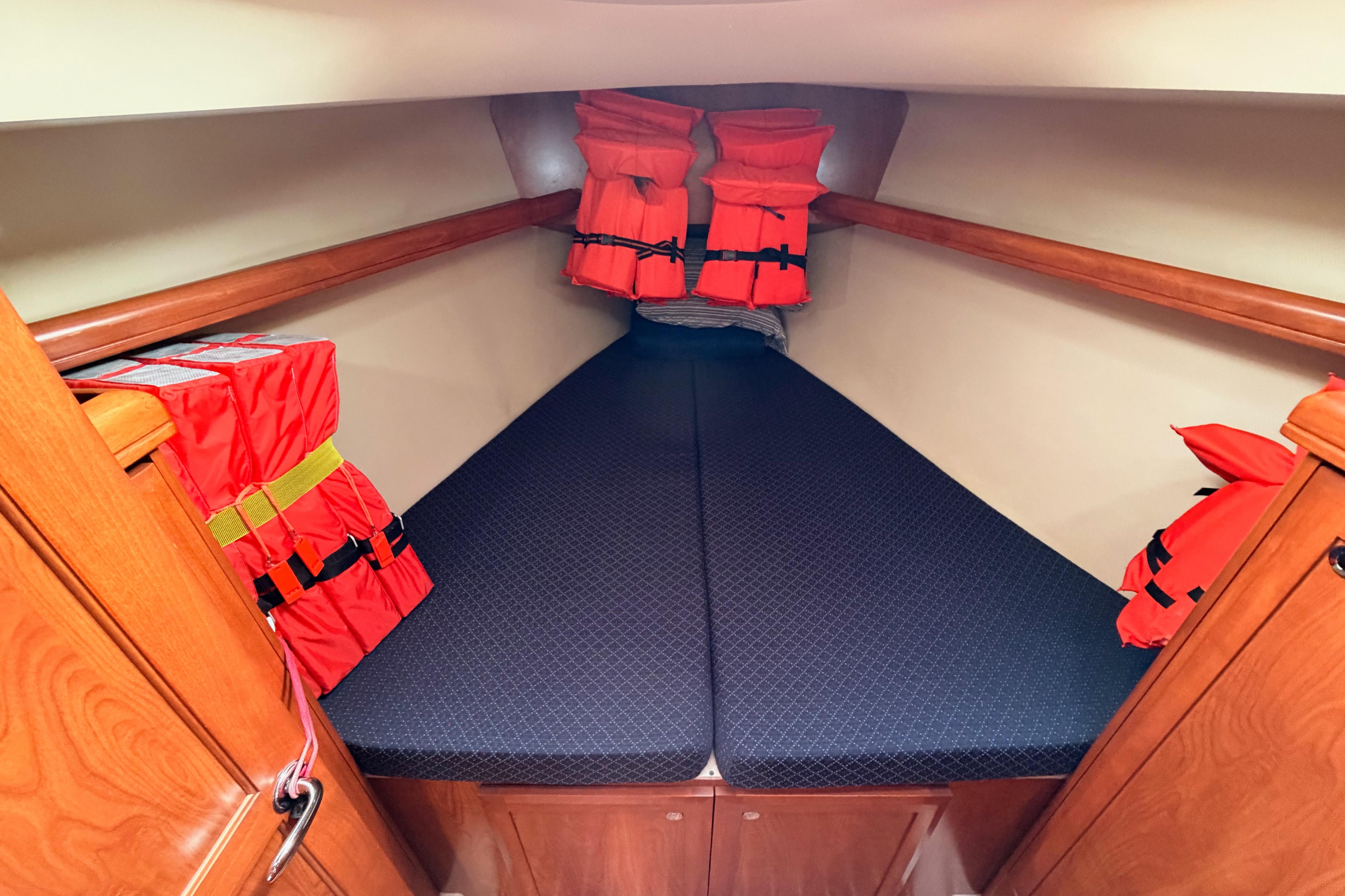 2009 Hunter 38 yacht cabin with life jackets and cozy bedding.