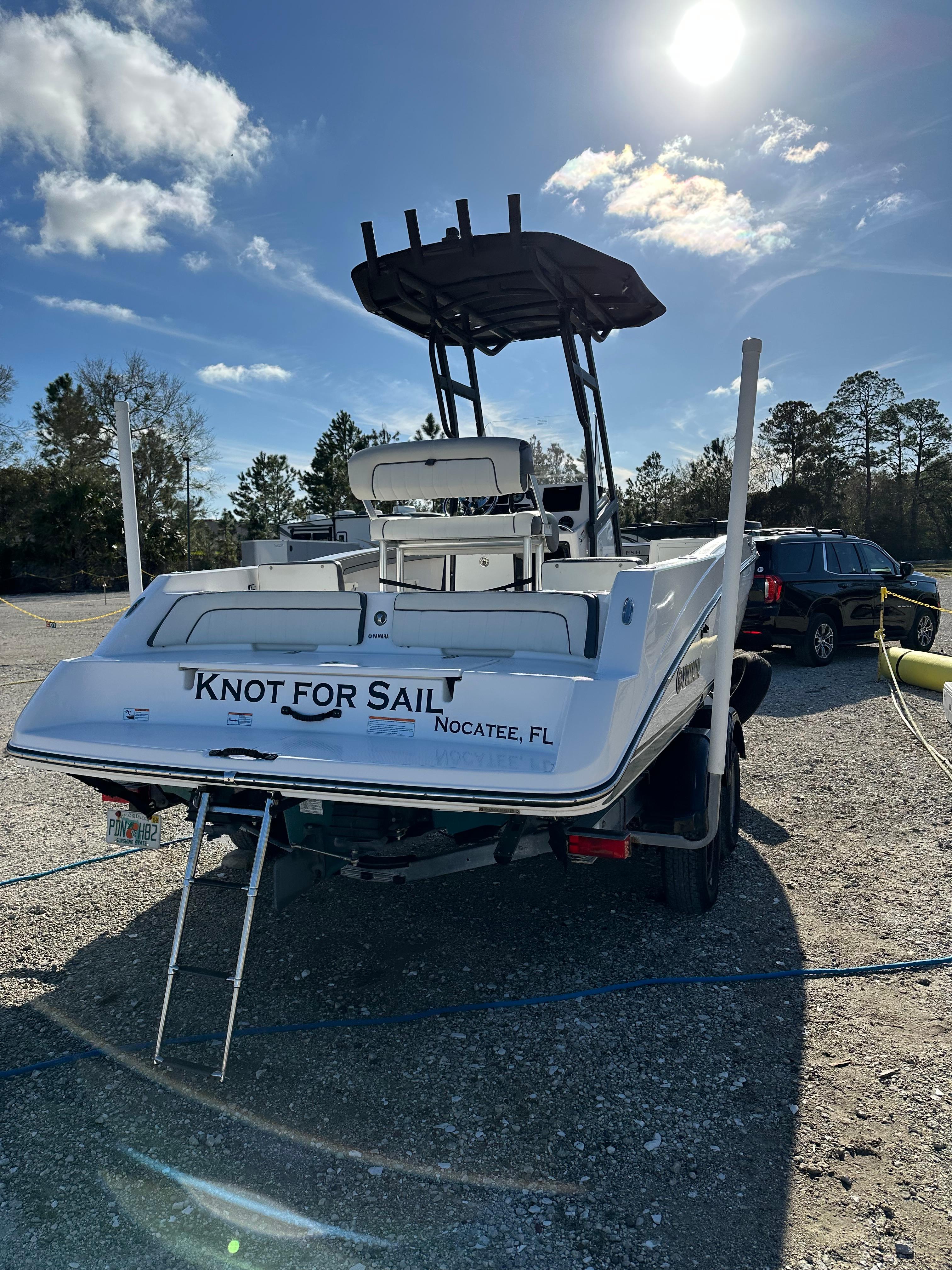 2021 Yamaha Boats 210 FSH Sport on trailer, sunny day, "Knot for Sail" text on stern.