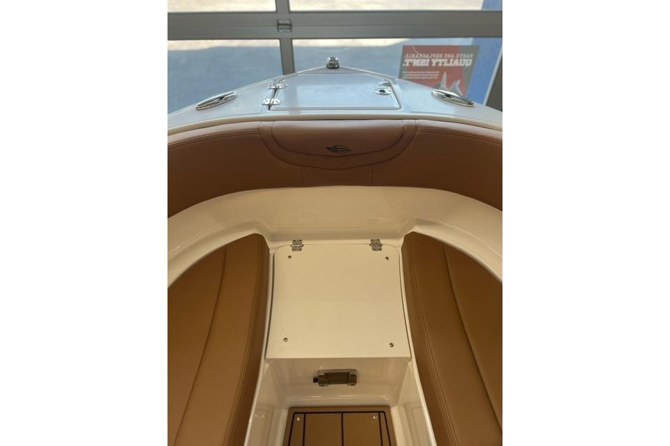 2025 Chaparral 247 SSX boat interior with brown seating and storage compartment.