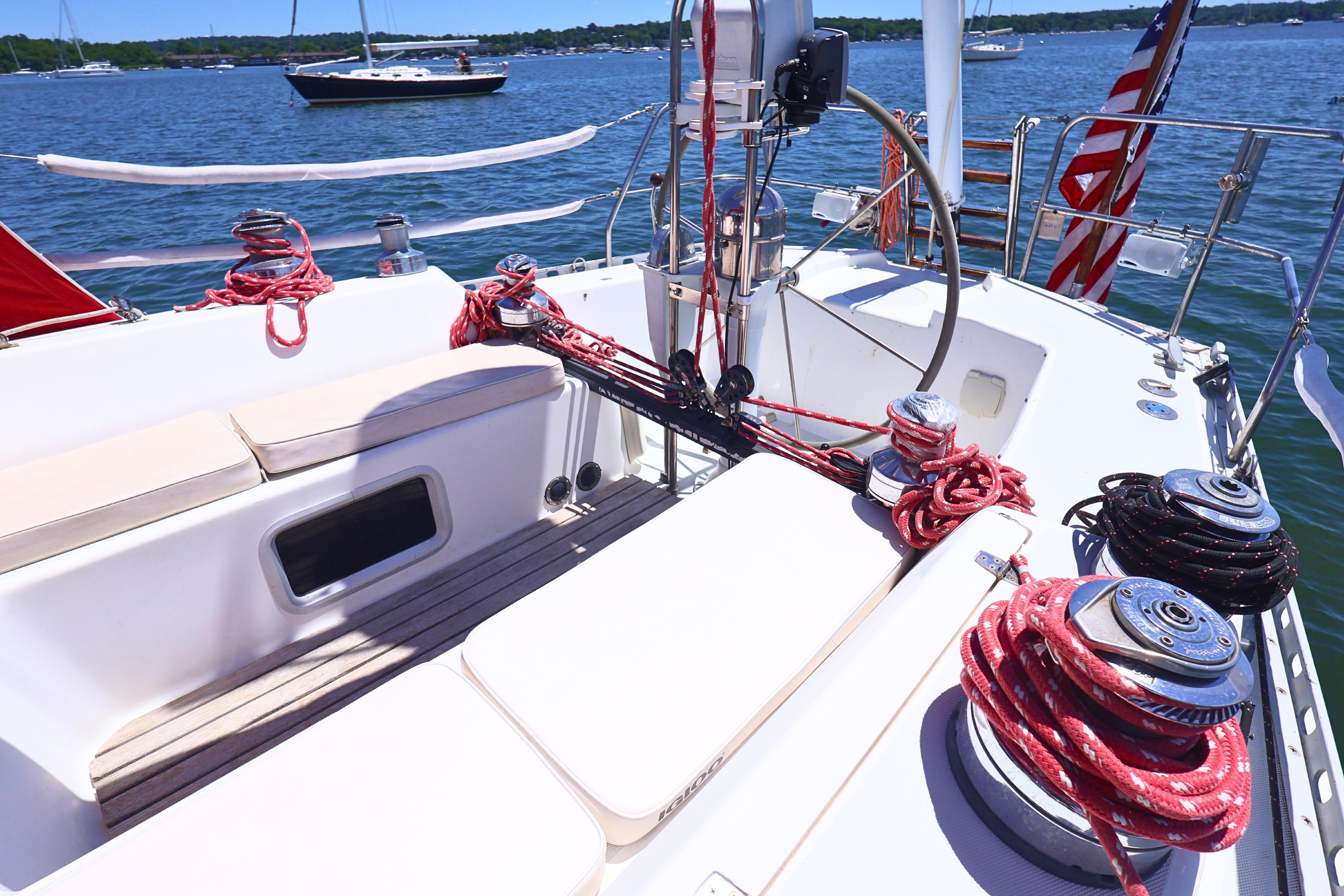Cockpit of 1989 J Boat J 40 sailboat with ropes and winches, docked on a sunny day.