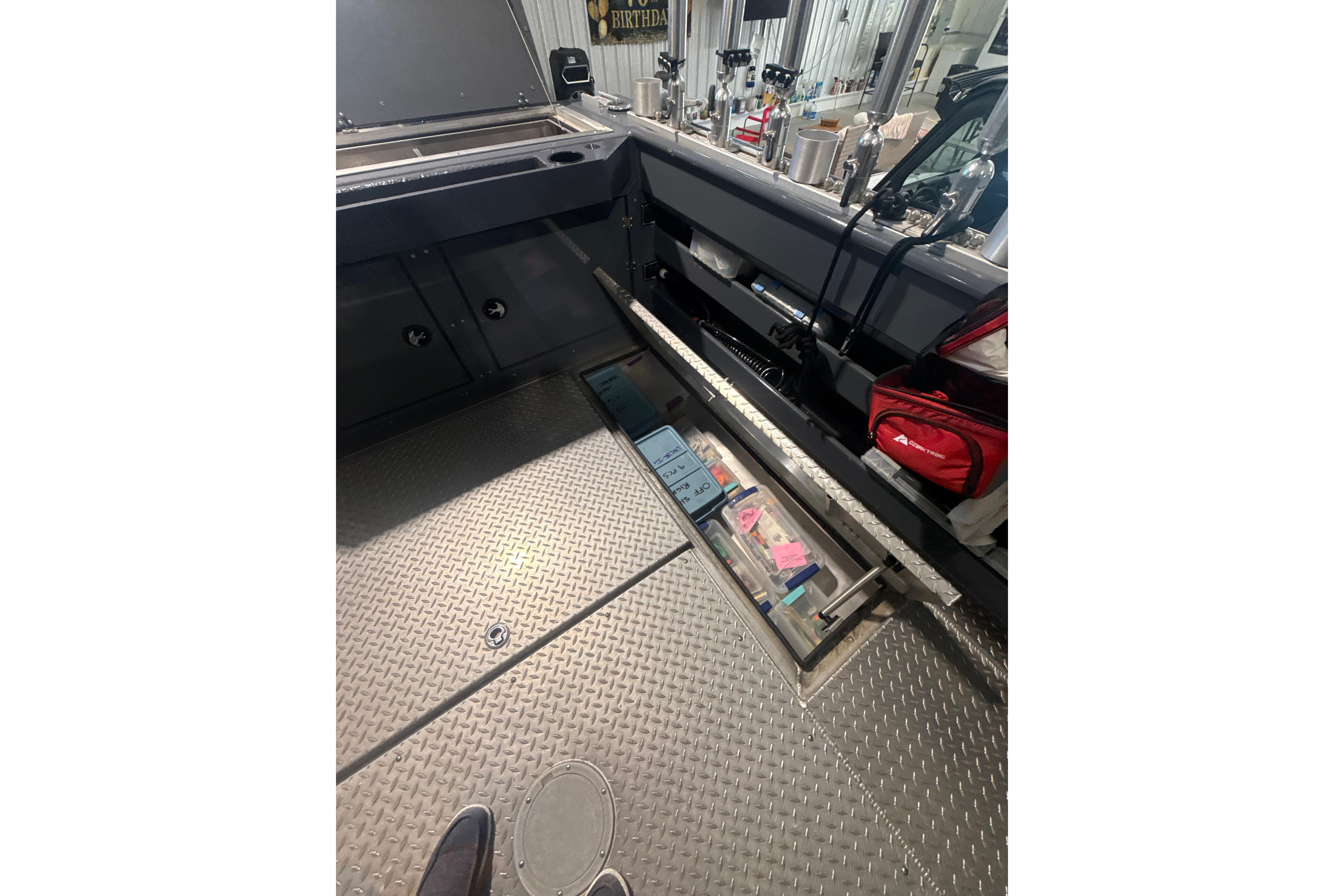 Interior view of 2022 Hewescraft 270 Alaskan Hardtop with storage compartments and equipment.