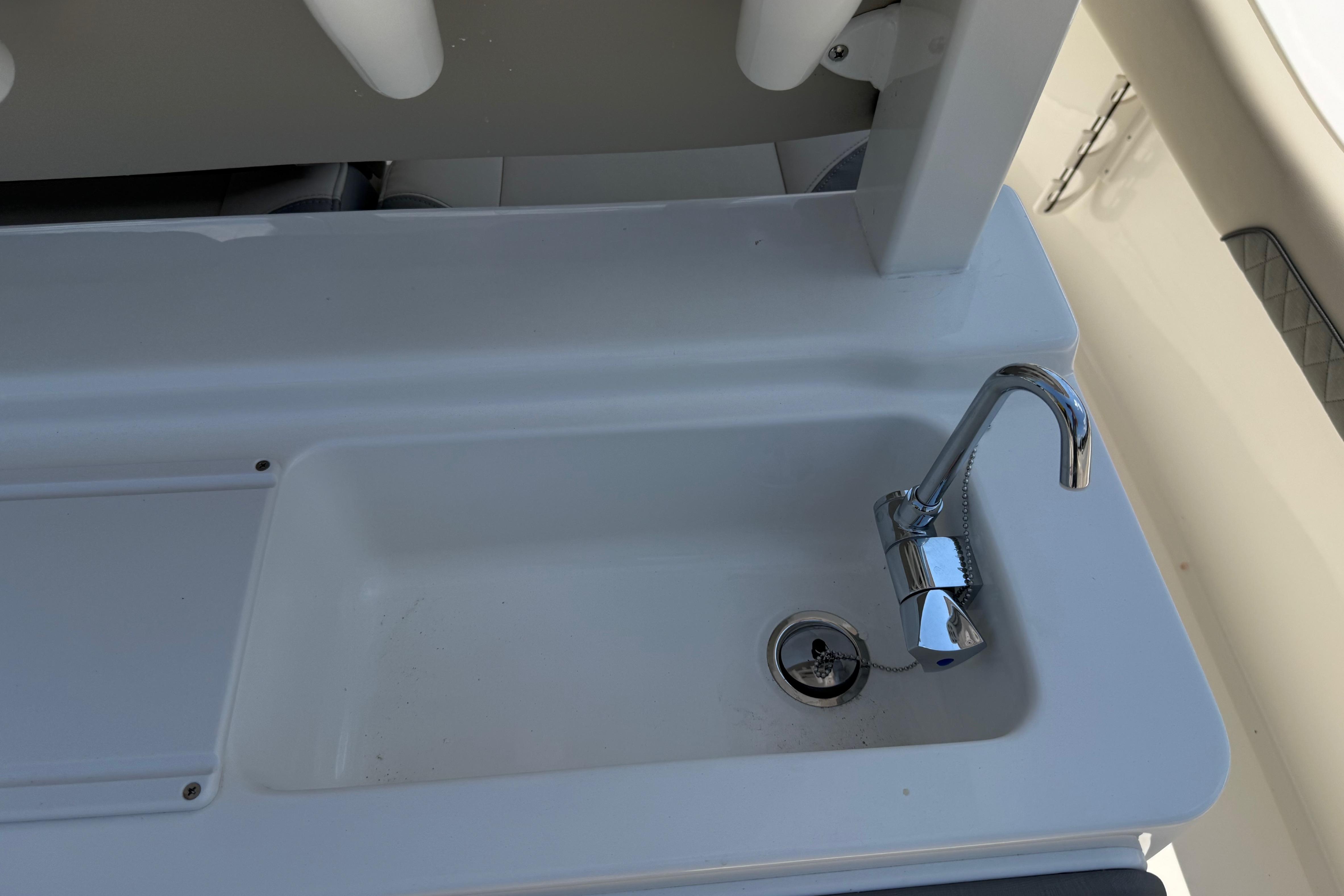Key West 249 FS 2027 boat sink with chrome faucet and drain plug.