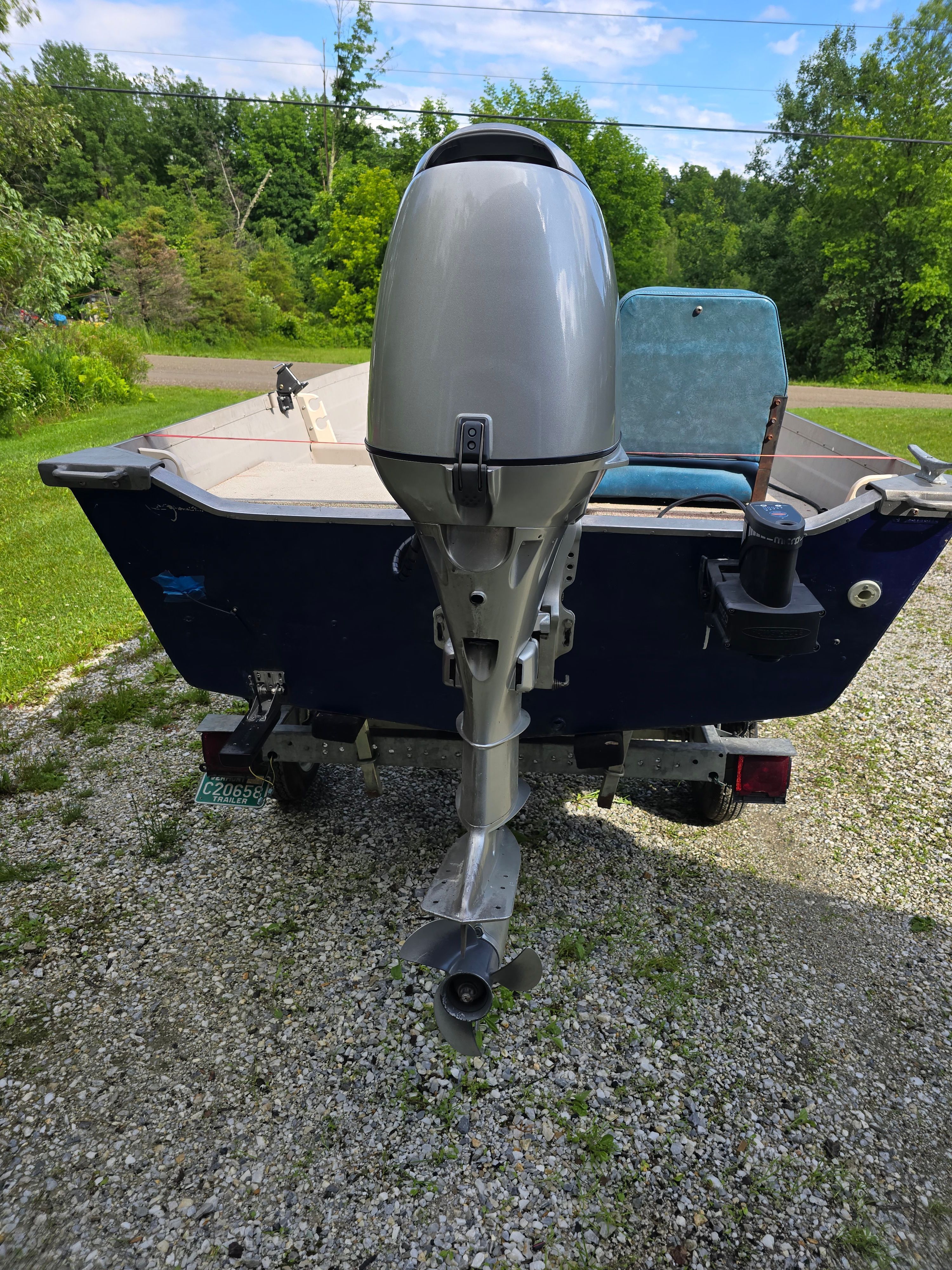 A 2002 Starcraft SF 14 L SS Utility Boat with an outboard motor on a trailer.