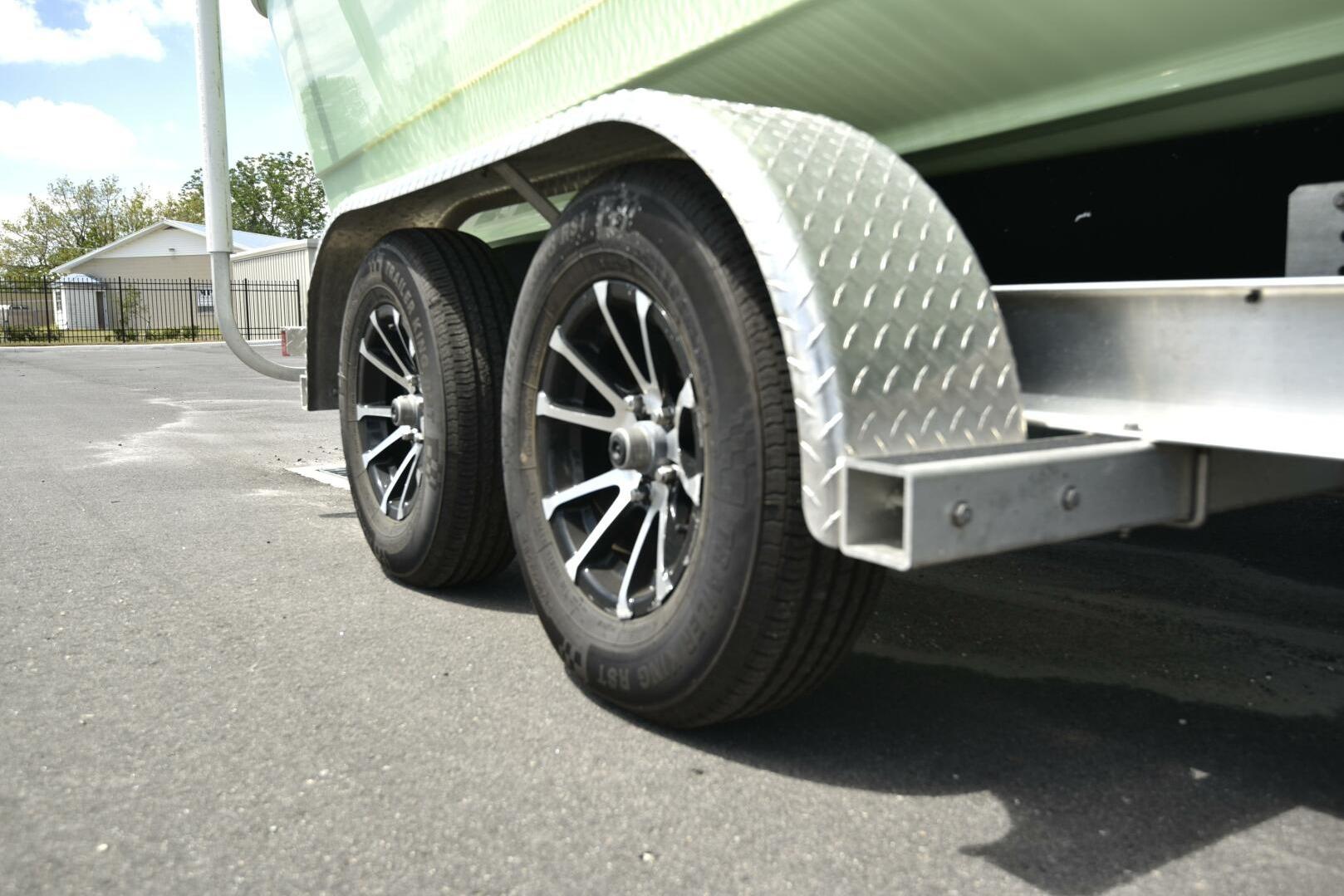 Trailer wheels of 2023 Sea Pro 239 Deep V CC boat on pavement.