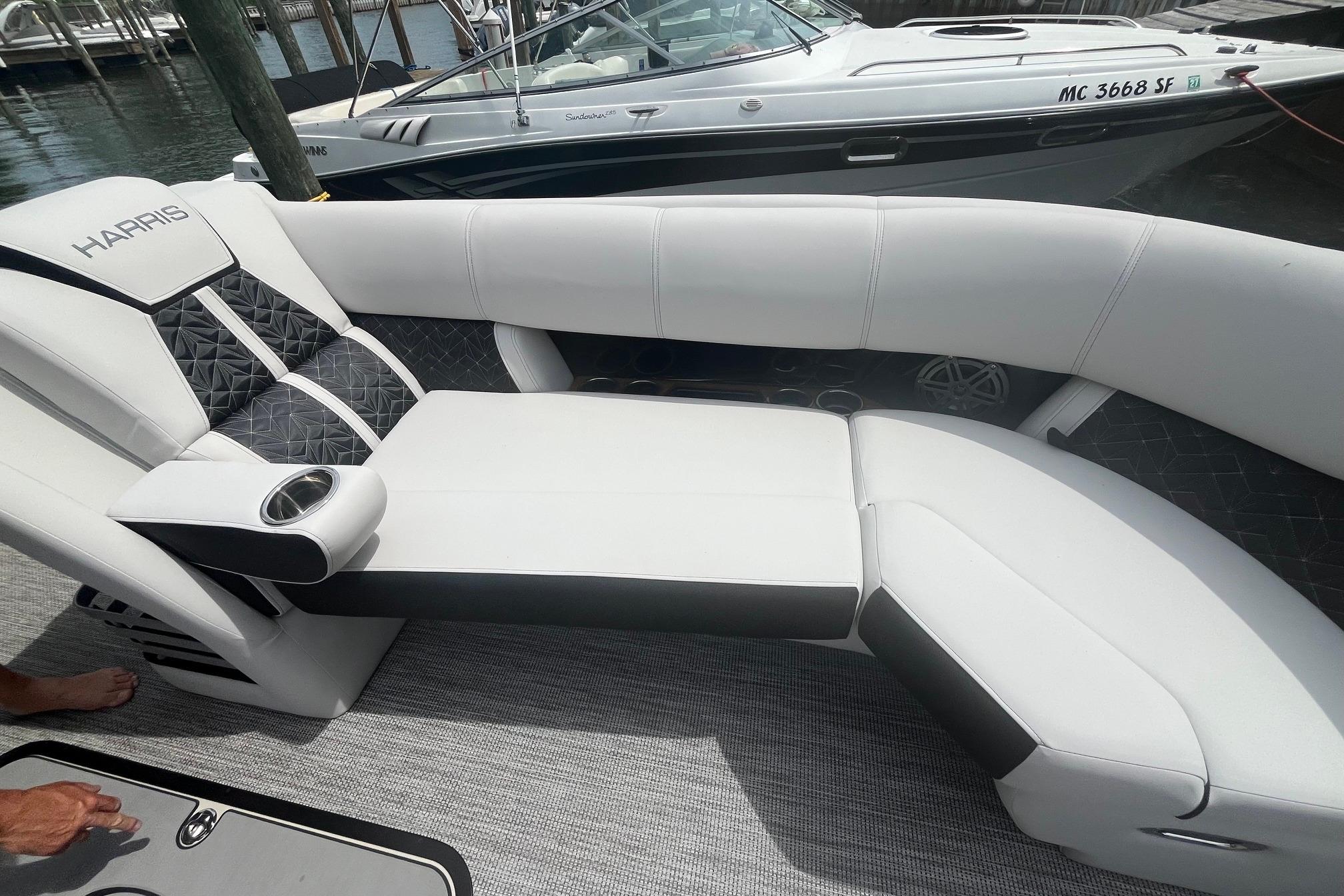 Luxurious seating on 2024 Harris Grand Mariner 250 boat, featuring sleek white and black upholstery.