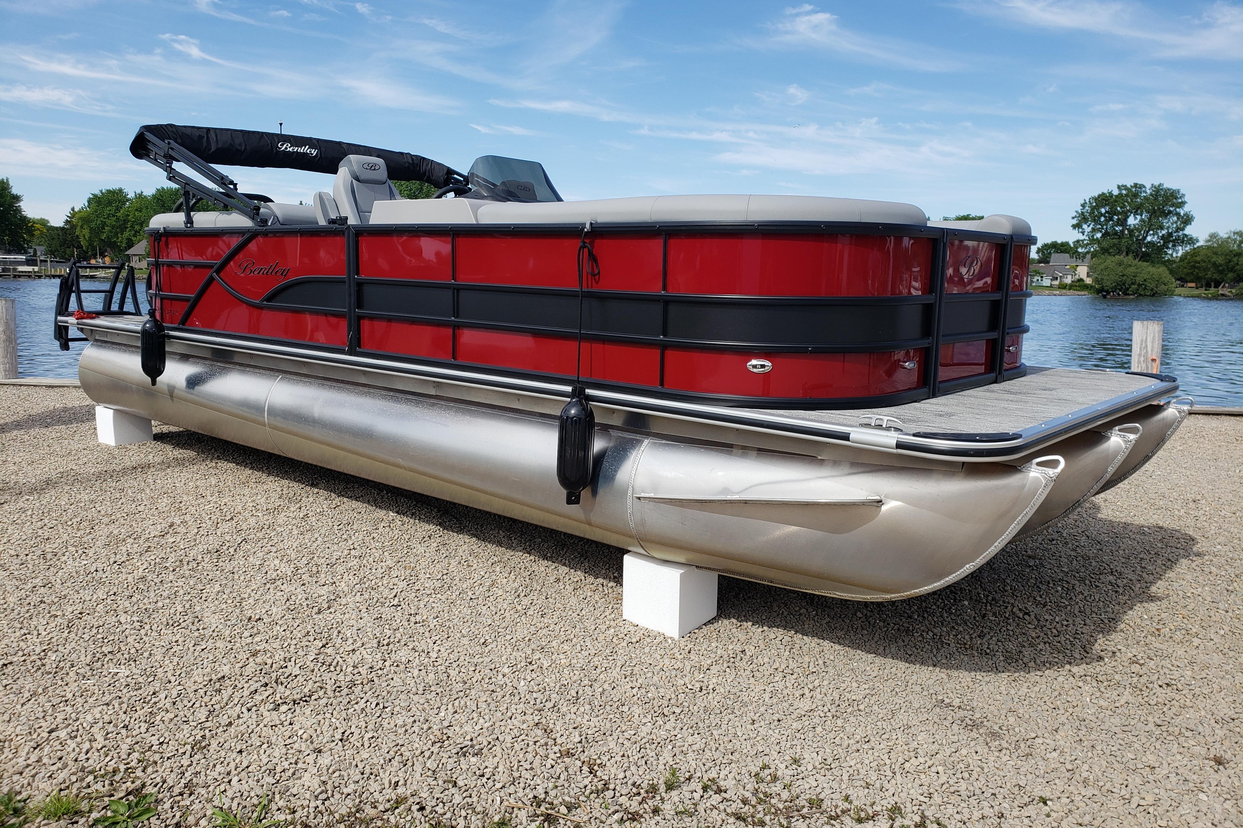 2026 Bentley Pontoons Legacy 243 Navigator Ext on gravel near water.