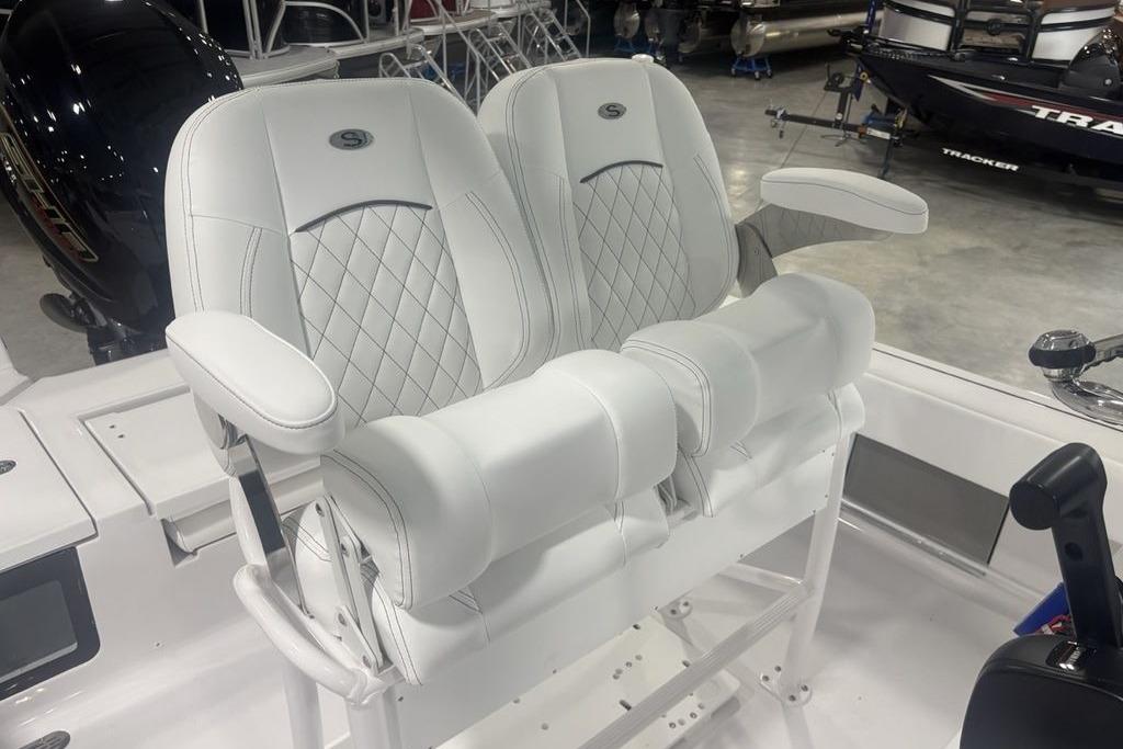 Luxury seating on 2026 Sportsman Masters 227 boat, featuring white cushioned armchairs.