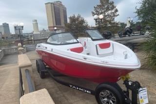 2025 Tahoe 200 S boat in vibrant red and white, parked on a city street.