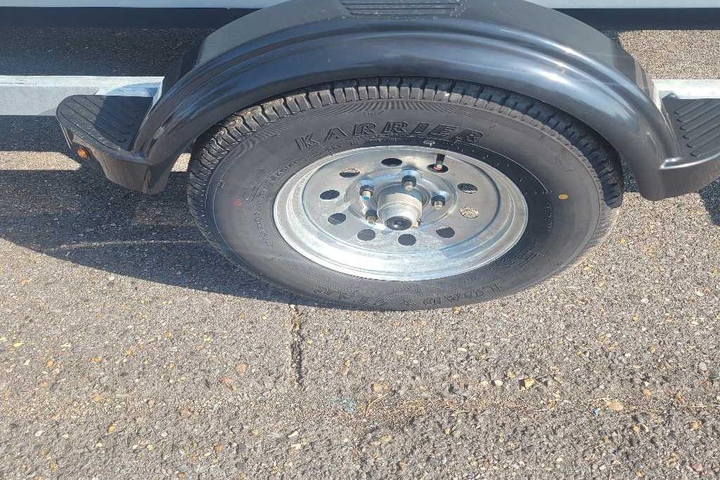 Trailer wheel of a 2026 Mako Pro Skiff 17 CC on asphalt.