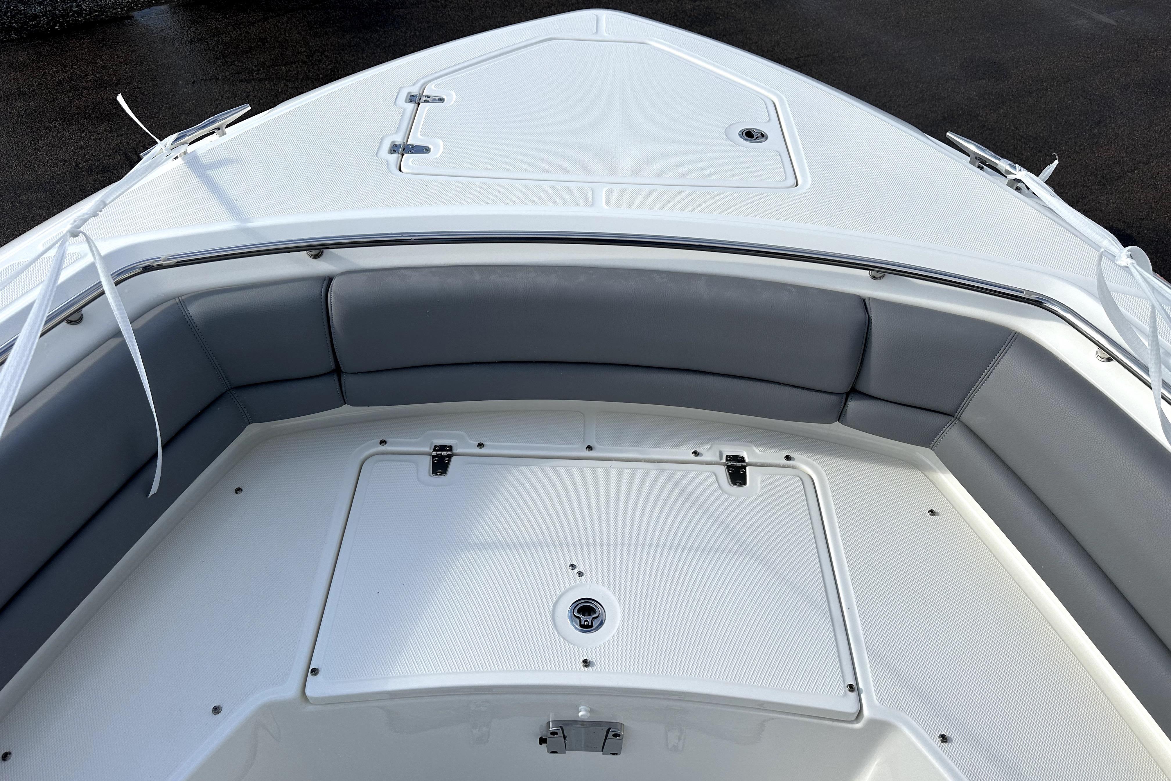 2023 Boston Whaler OUTRAGE boat interior with cushioned seating and storage compartment.