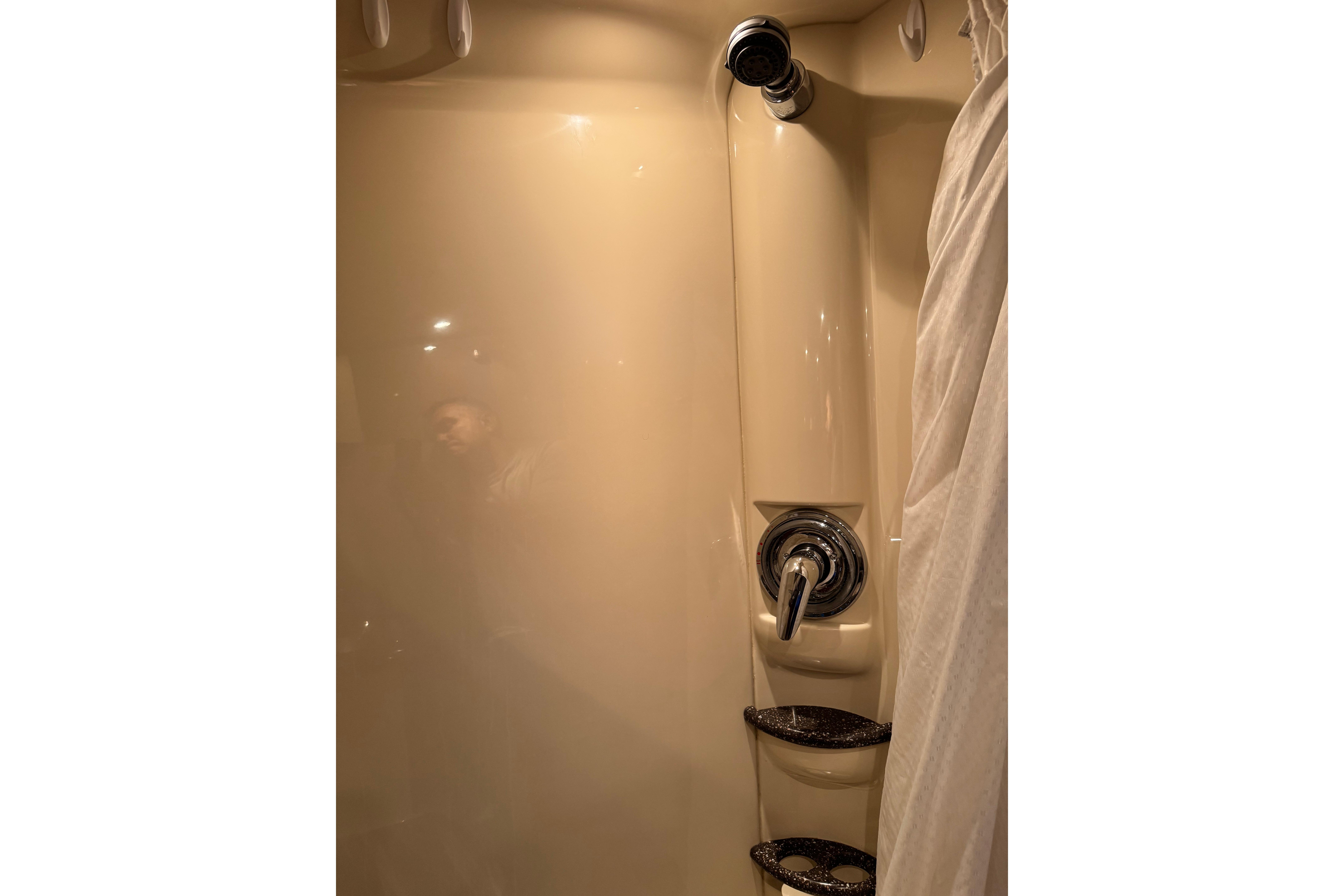 Shower area in 2008 Formula 400 Super Sport boat with chrome fixtures and curtain.