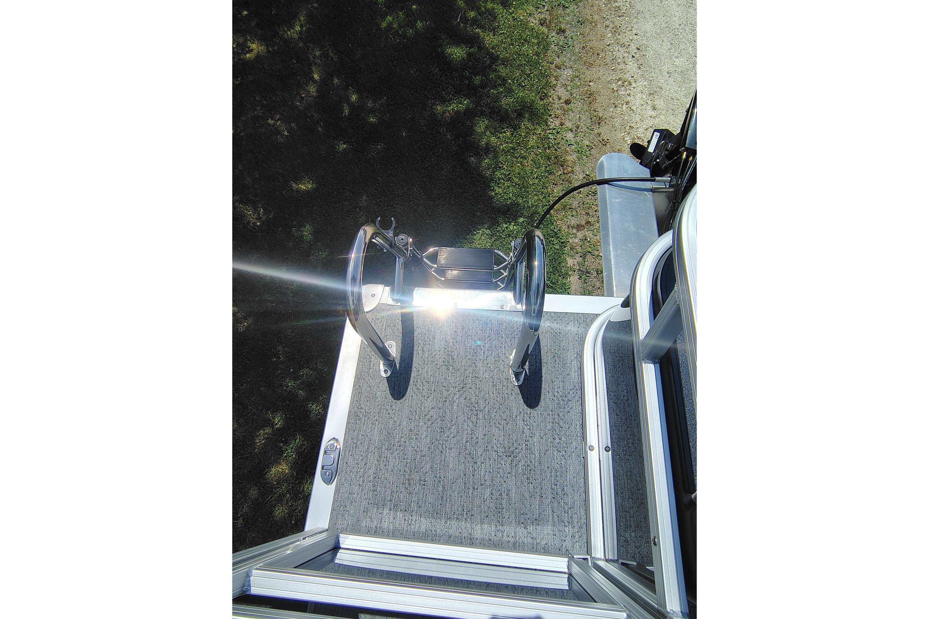 2026 Sun Tracker Bass Buggy 18 DLX boat deck with ladder and railing in sunlight.