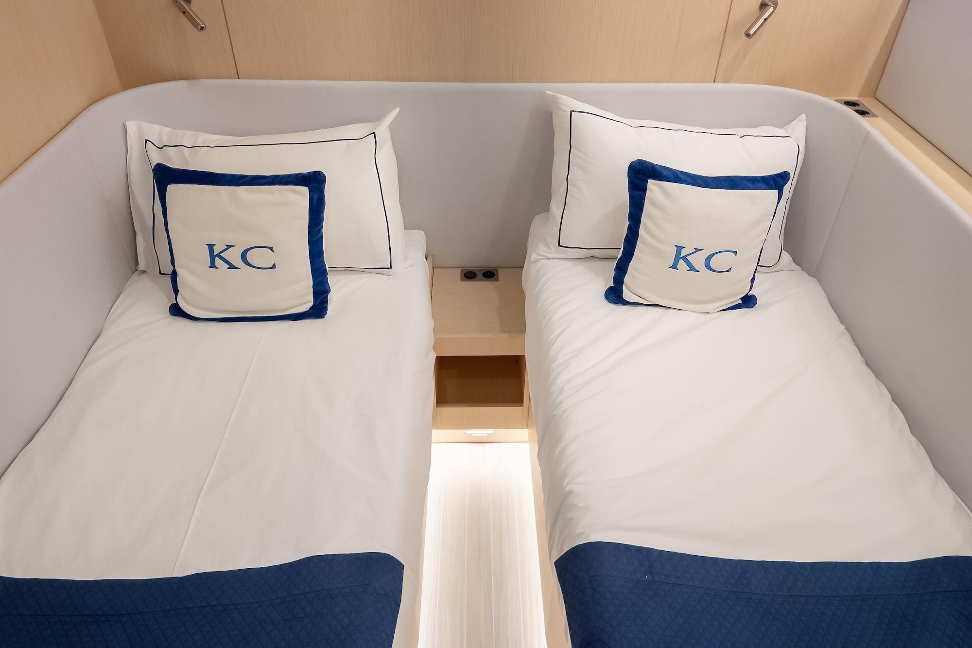 Luxurious twin cabin in 2024 YYachts Y8, featuring elegant bedding and personalized pillows.