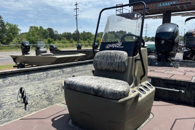 2026 Tracker Grizzly 2072 CC boat with camo seating, displayed outdoors.