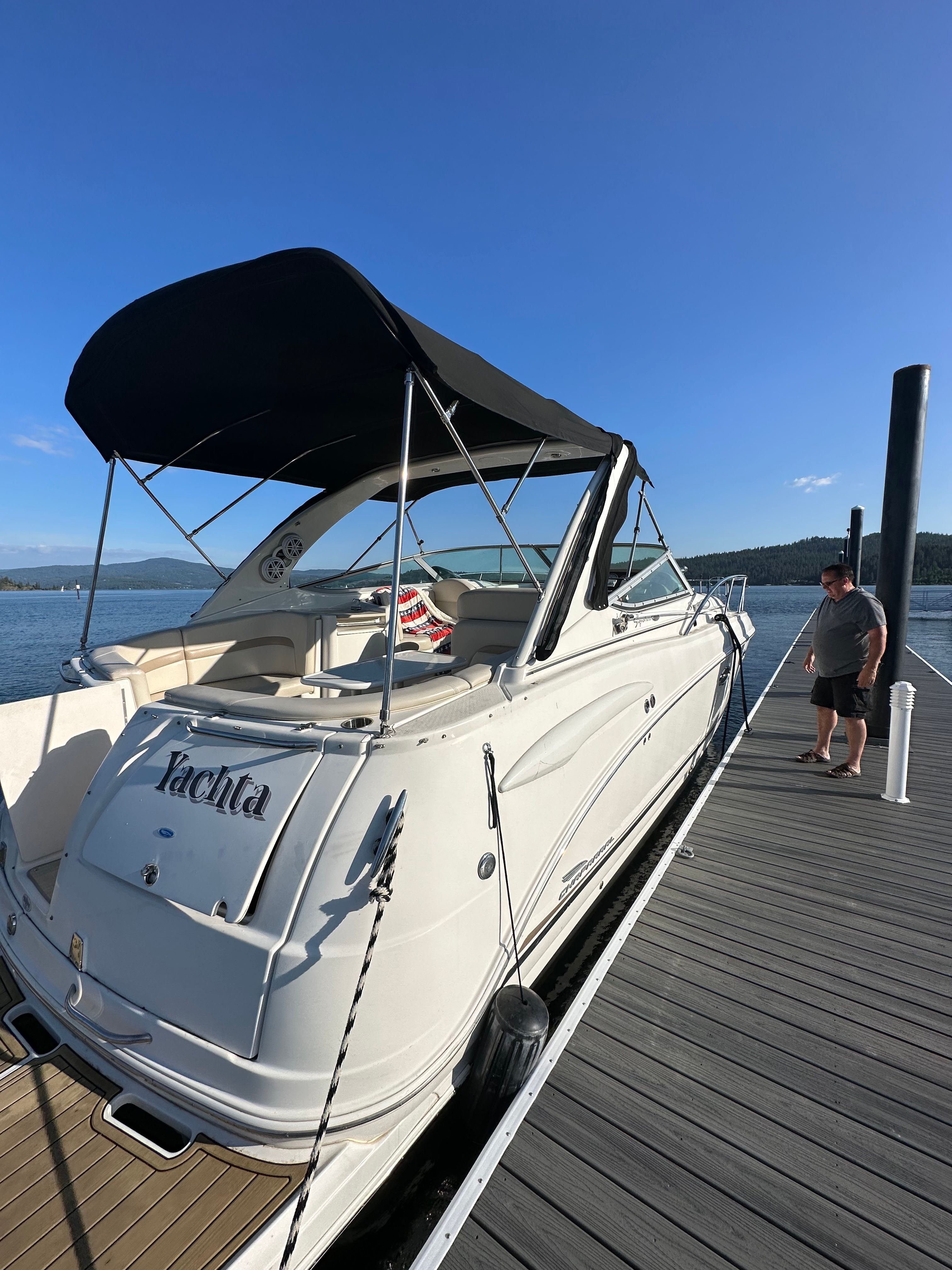 A white 2004 Chaparral Signature 330 boat docked at a sunny pier.
