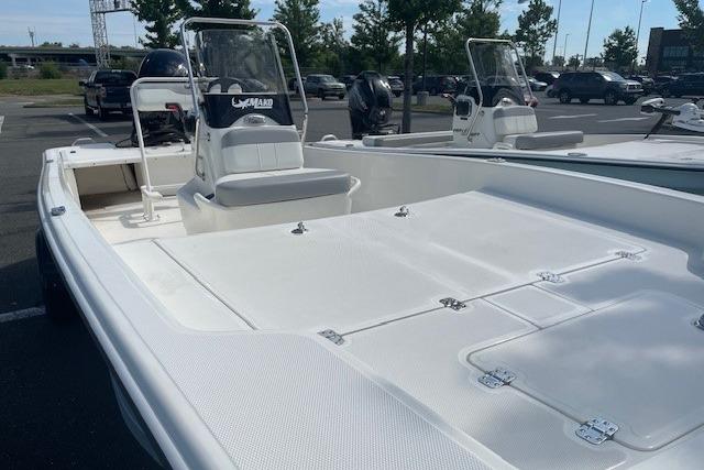2026 Mako Pro Skiff 17 CC boat in a parking lot, showcasing spacious deck and seating.