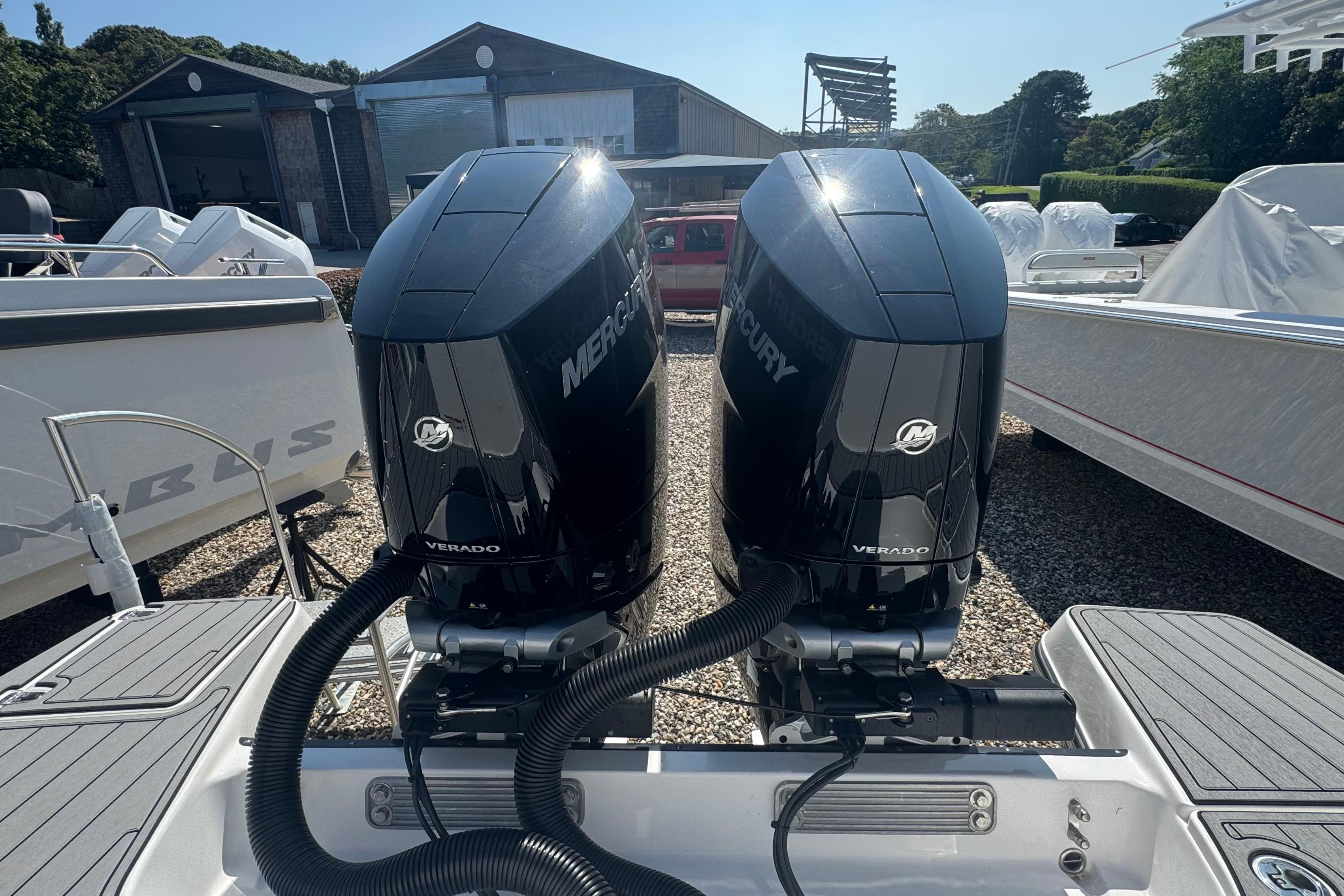 Twin Mercury Verado engines on a 2025 Edgewater 340CC boat, parked outdoors.