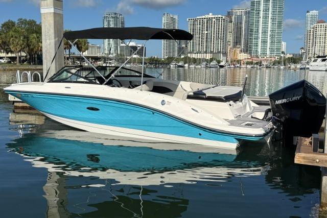 2022 Sea Ray SPX 210 Outboard boat docked in a marina with city skyline.