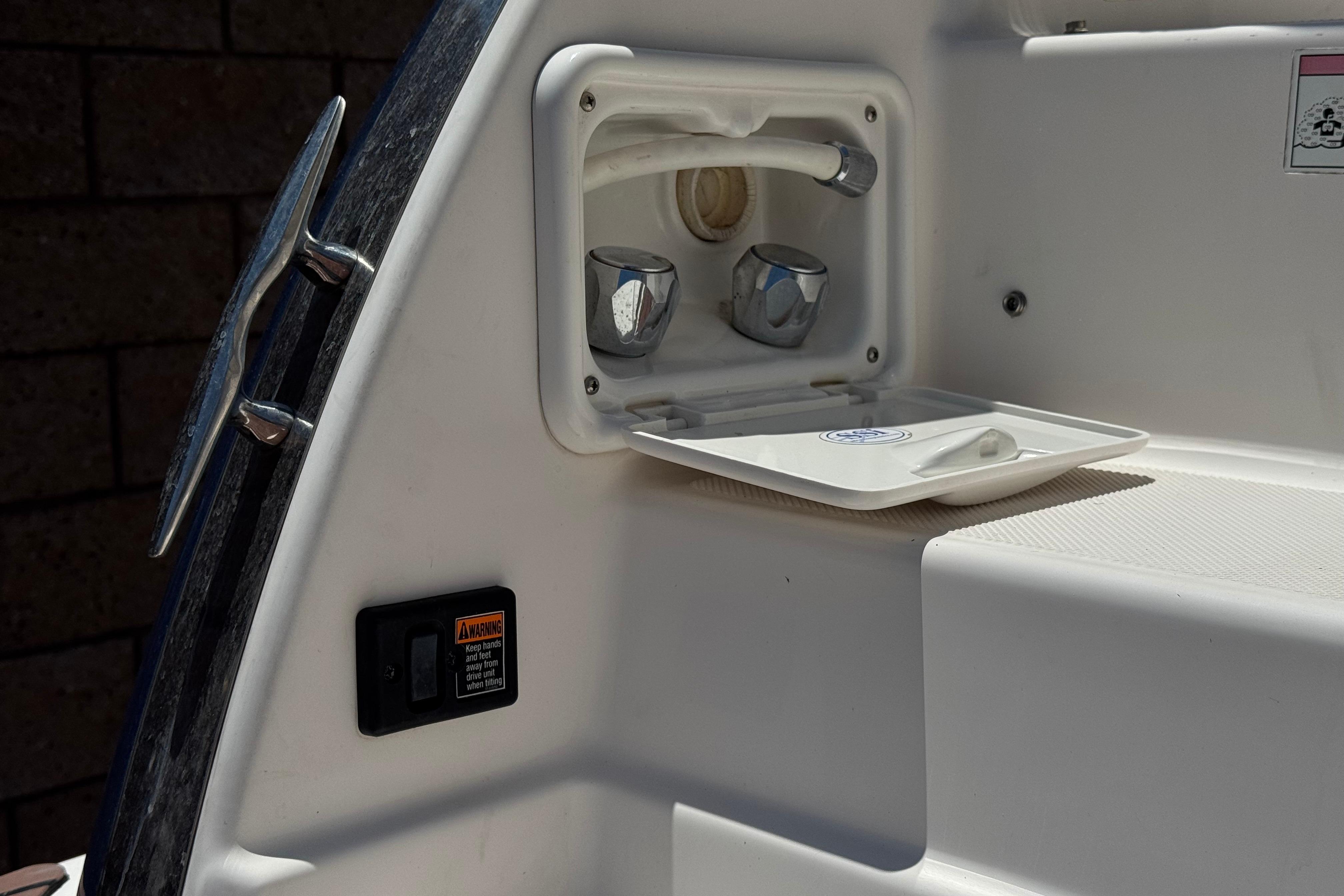 2013 Regal 28 Express boat shower compartment with faucet and warning label.