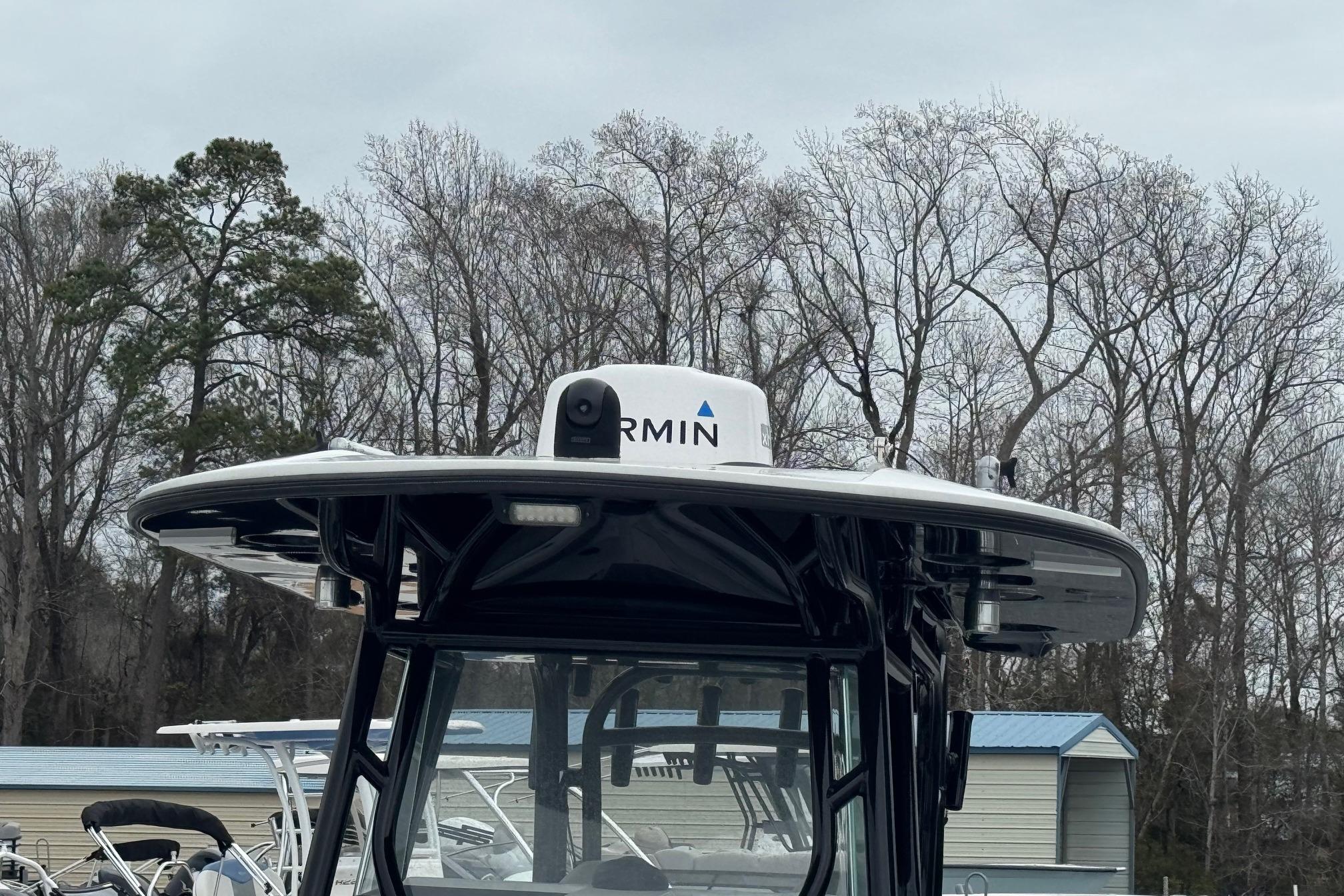 2024 Cape Horn 32 XS boat with Garmin radar, surrounded by trees and overcast sky.