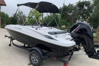 2026 Tahoe T16 boat with Mercury engine on trailer, parked outdoors.