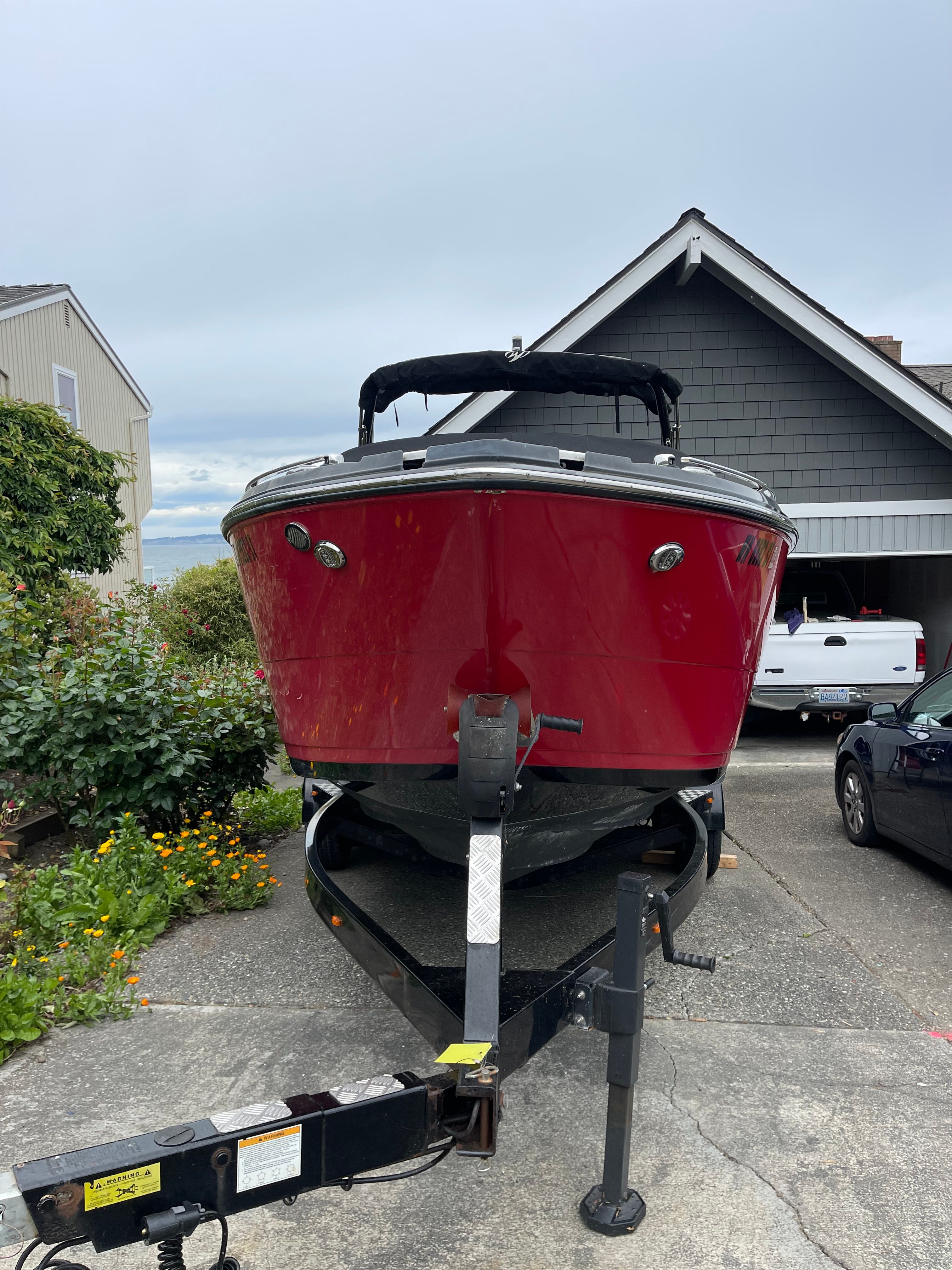 Red 2019 Monterey 258SS boat on trailer in front of house.