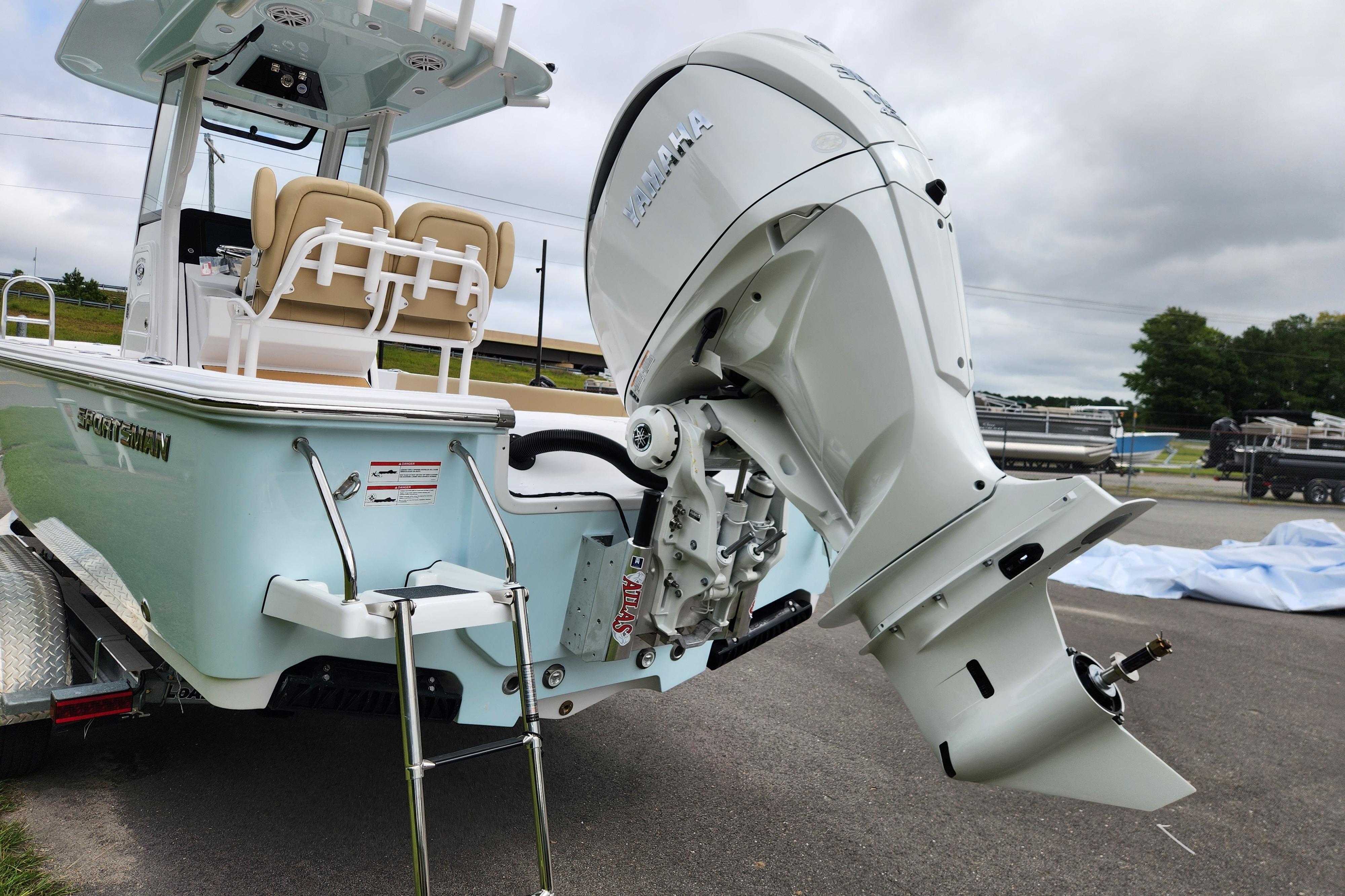 2026 Sportsman Masters 247 Bay Boat with powerful outboard motor, parked on a trailer.