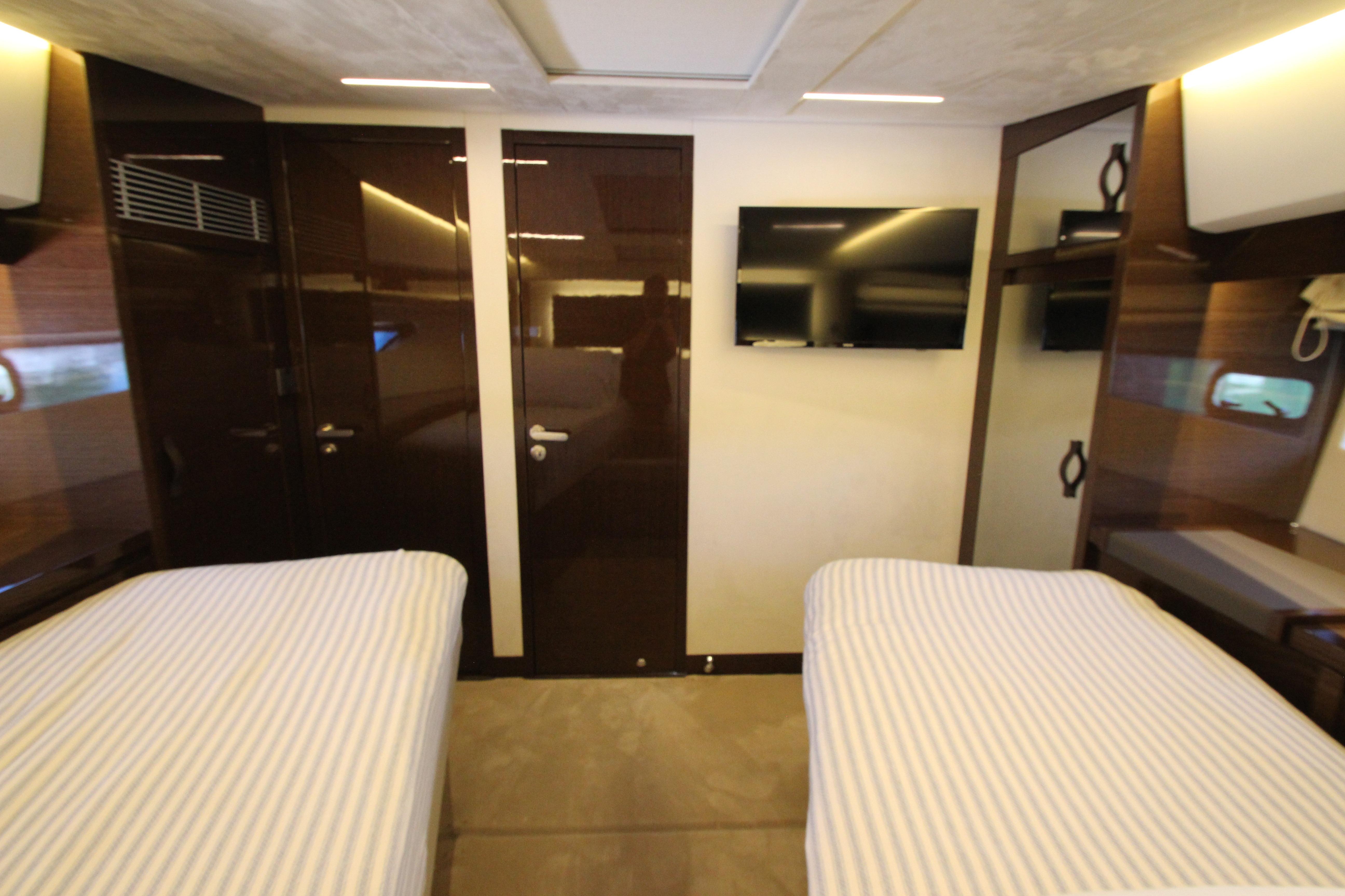 Luxurious 2022 Prestige 520 yacht cabin with twin beds and modern amenities.
