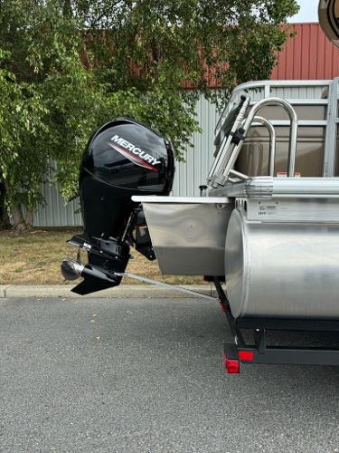 2025 Sun Tracker SportFish 22 XP3 with Mercury outboard motor, parked outdoors.