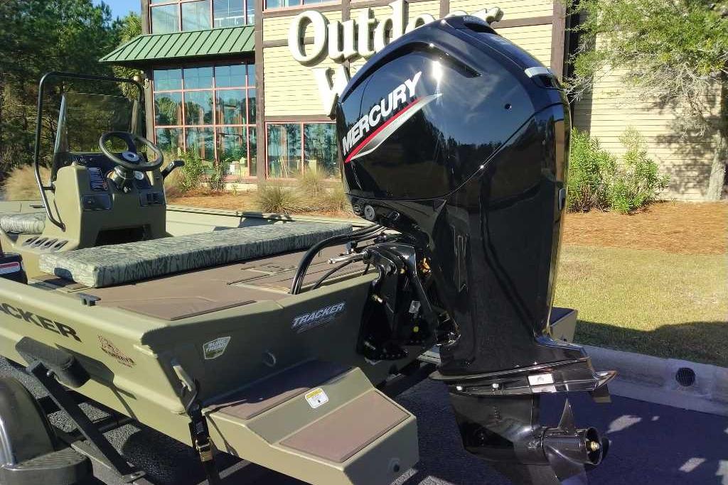 2026 Tracker Grizzly 1860 CC boat with Mercury engine outside a store.
