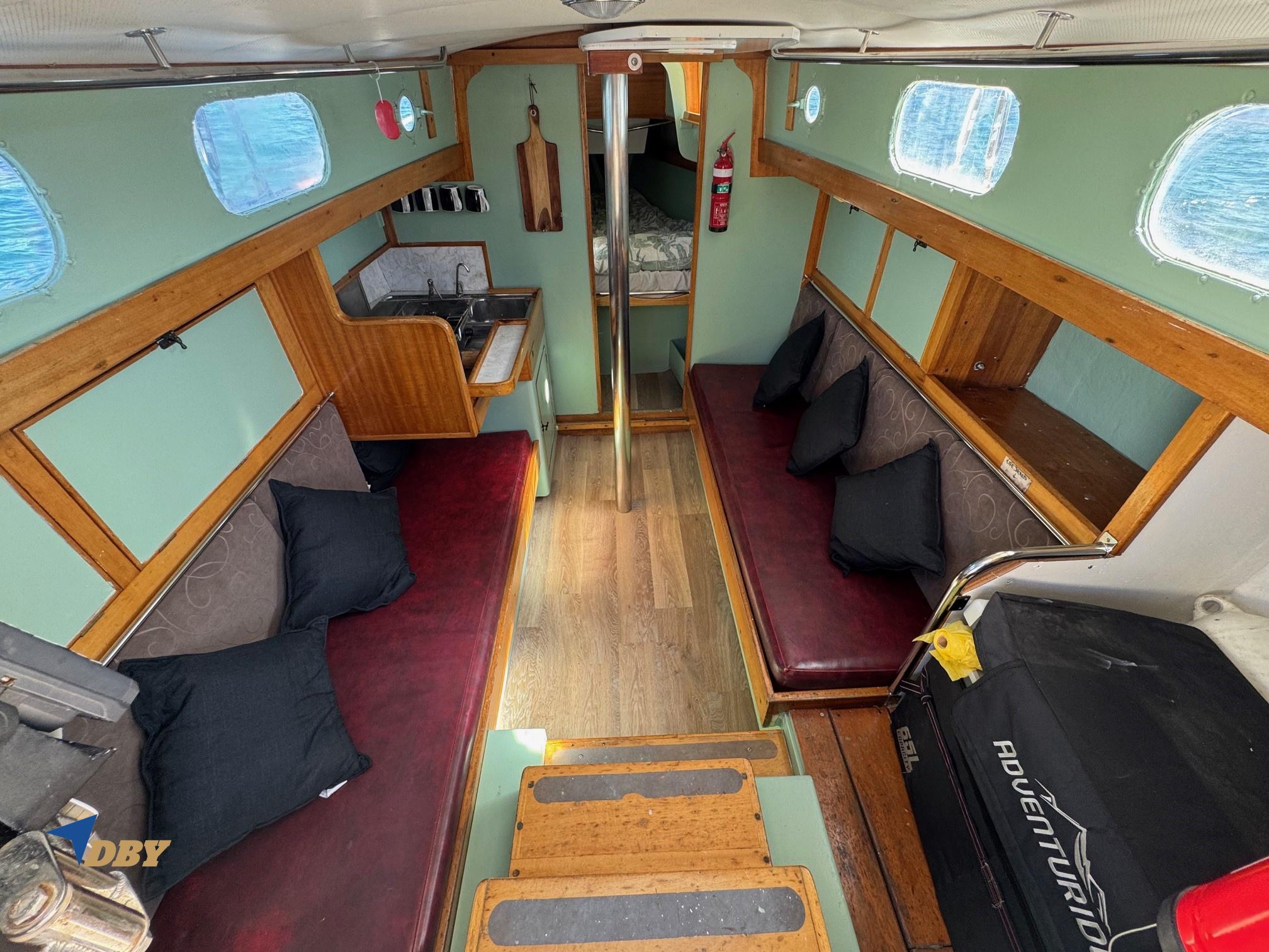 Interior of a 1970 Halvorsen 30 boat with cozy seating and wooden accents.