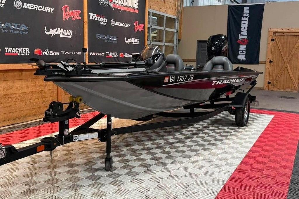 2024 Tracker Pro Team 175 boat on display in a showroom with promotional banners.