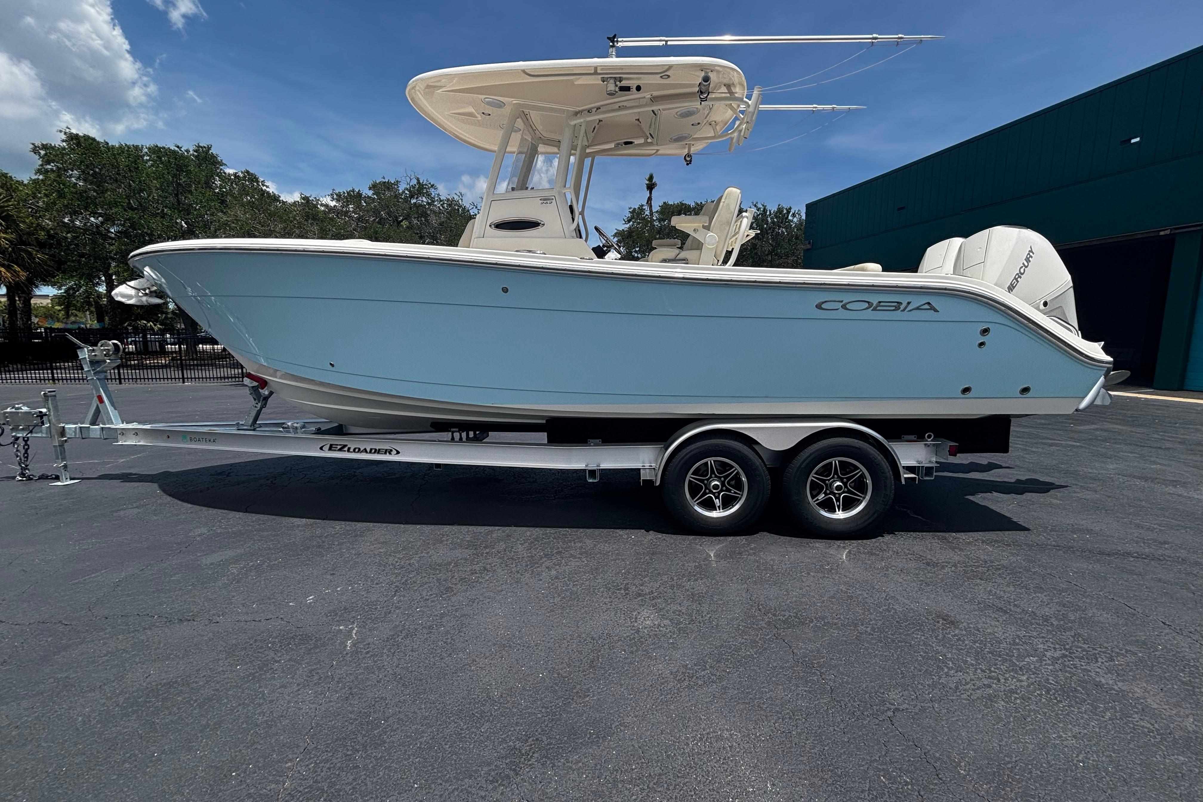 2023 Cobia 262 Center Console boat on trailer, parked outdoors under clear sky.