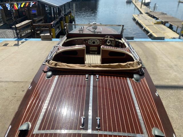 2000 Grand Craft Classic Runabout boat with wooden deck at a marina.