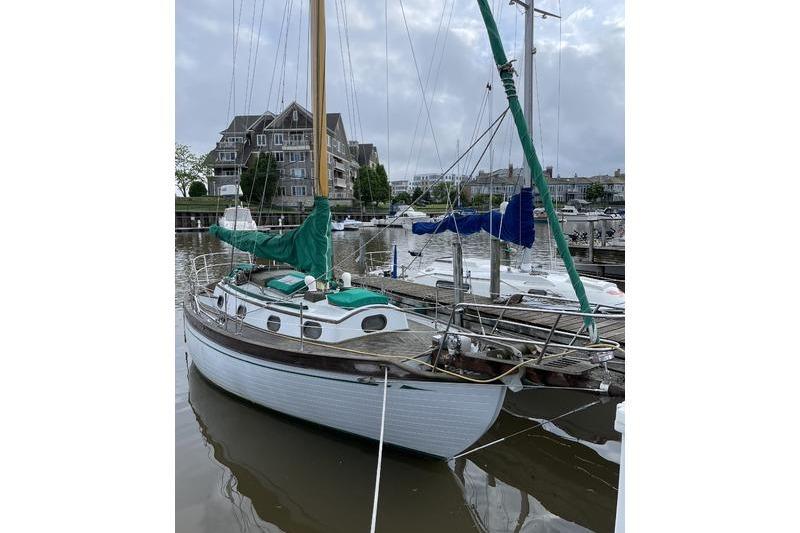 1980 Ta Shing Baba 30 sailboat docked in a marina with overcast skies.