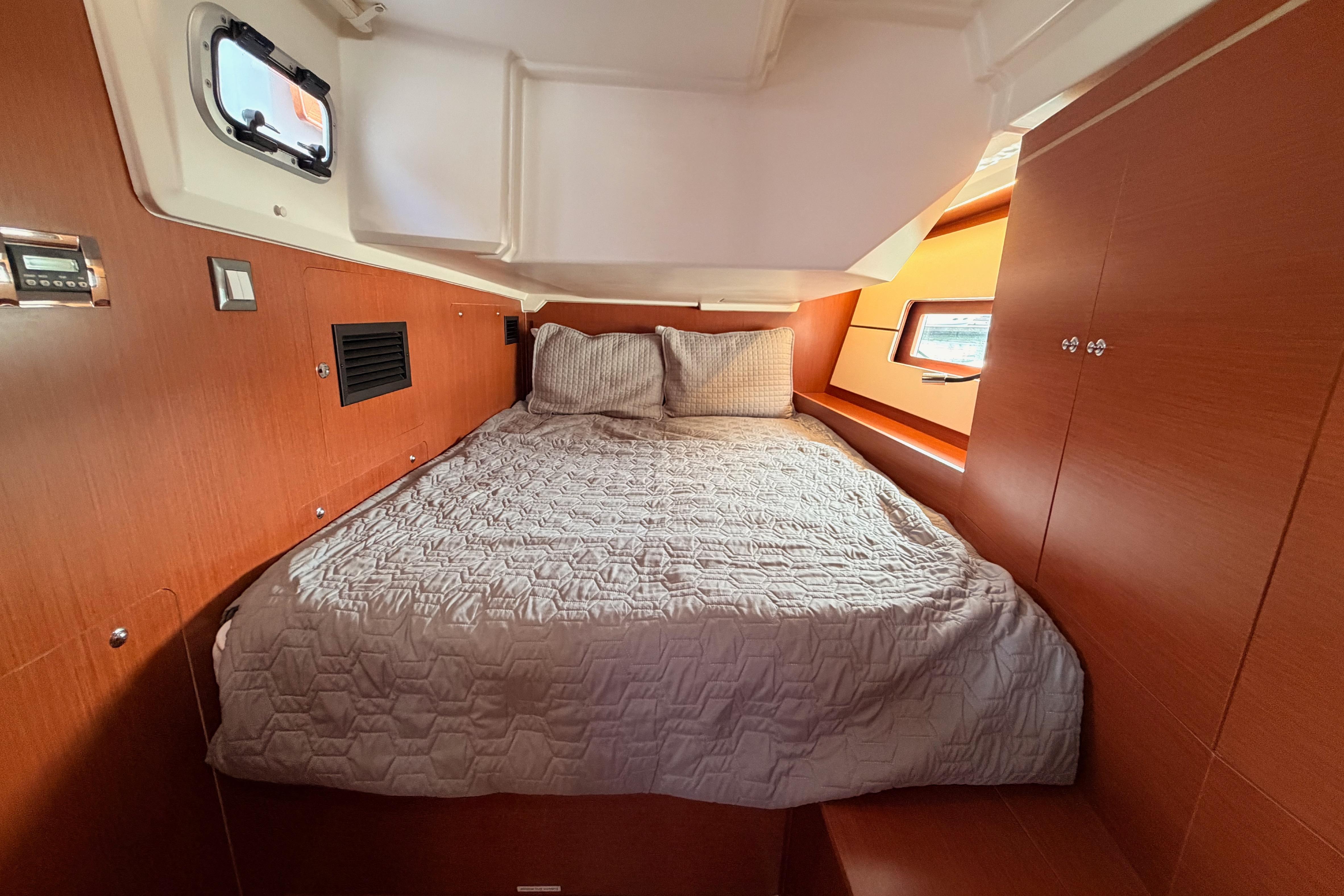 Cozy cabin interior of 2020 Beneteau Oceanis 46.1 yacht with wooden finish and comfortable bedding.