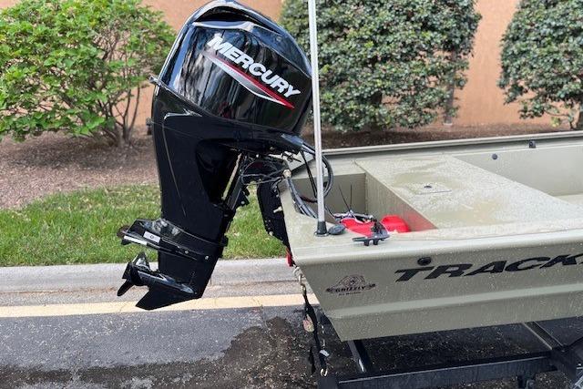2026 Tracker Grizzly 1648 SC boat with Mercury outboard motor, parked outdoors.