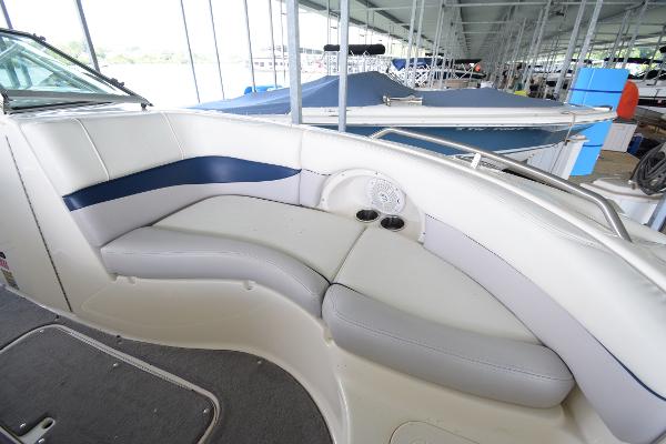 The image shows the cockpit of a 2010 Bryant 255 boat with white and blue seating.