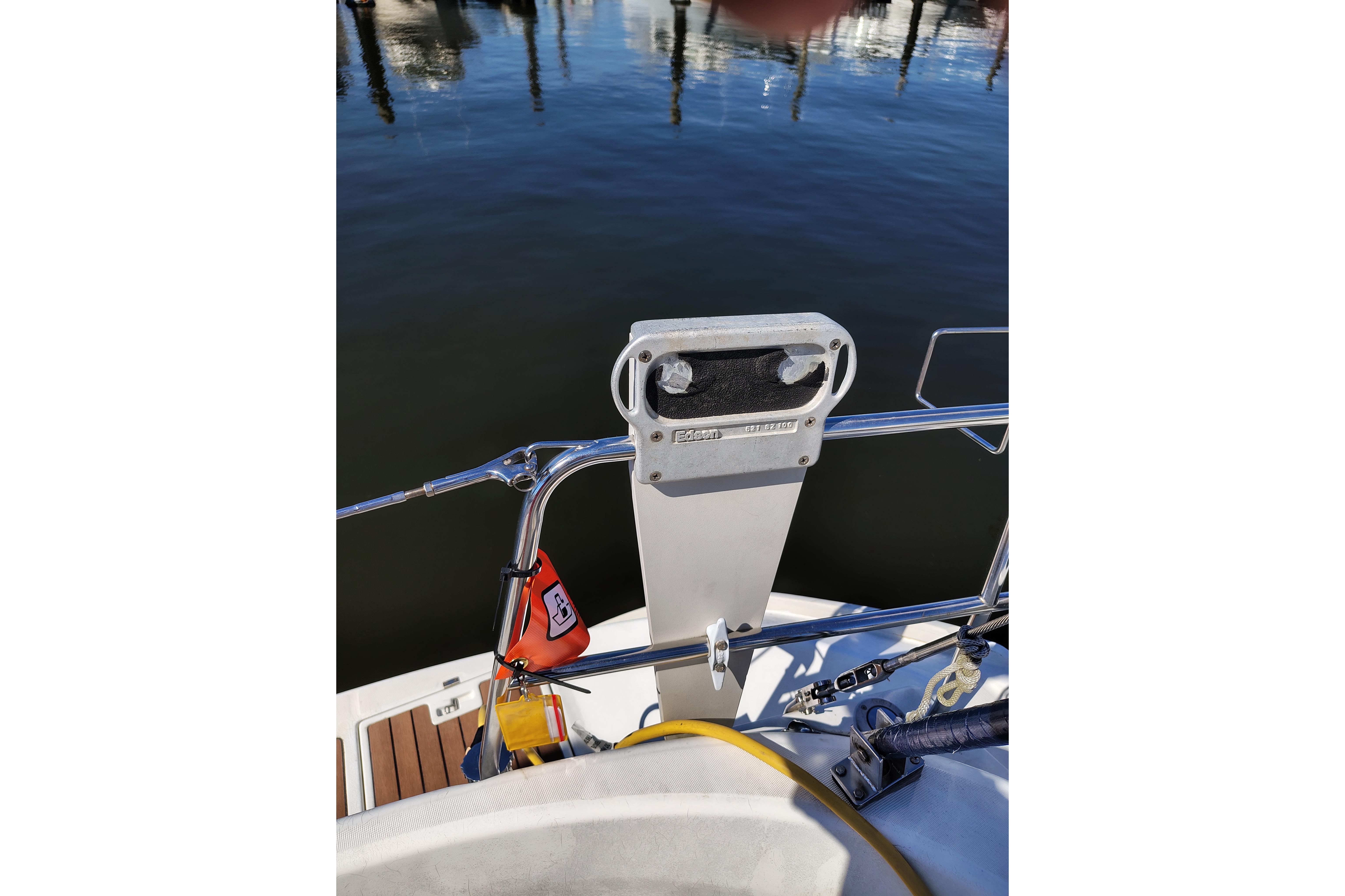 Beneteau Oceanis 411 sailboat stern view, featuring safety equipment and marina background.